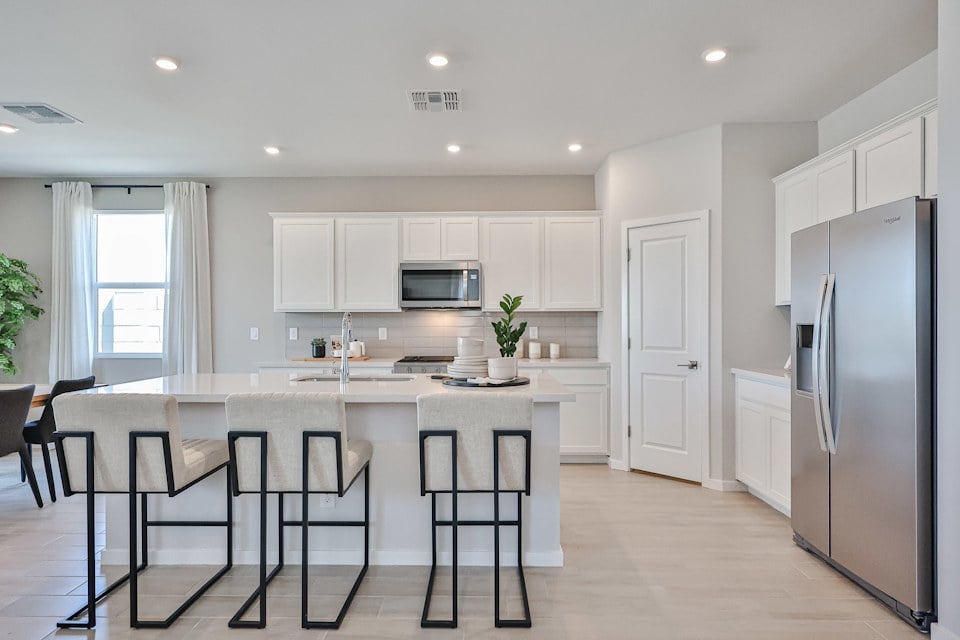 A kitchen with white cabinets.
