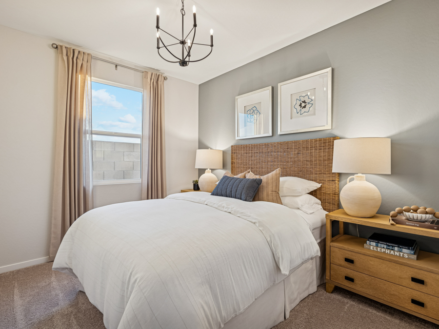 A bedroom with a bed and lamps.