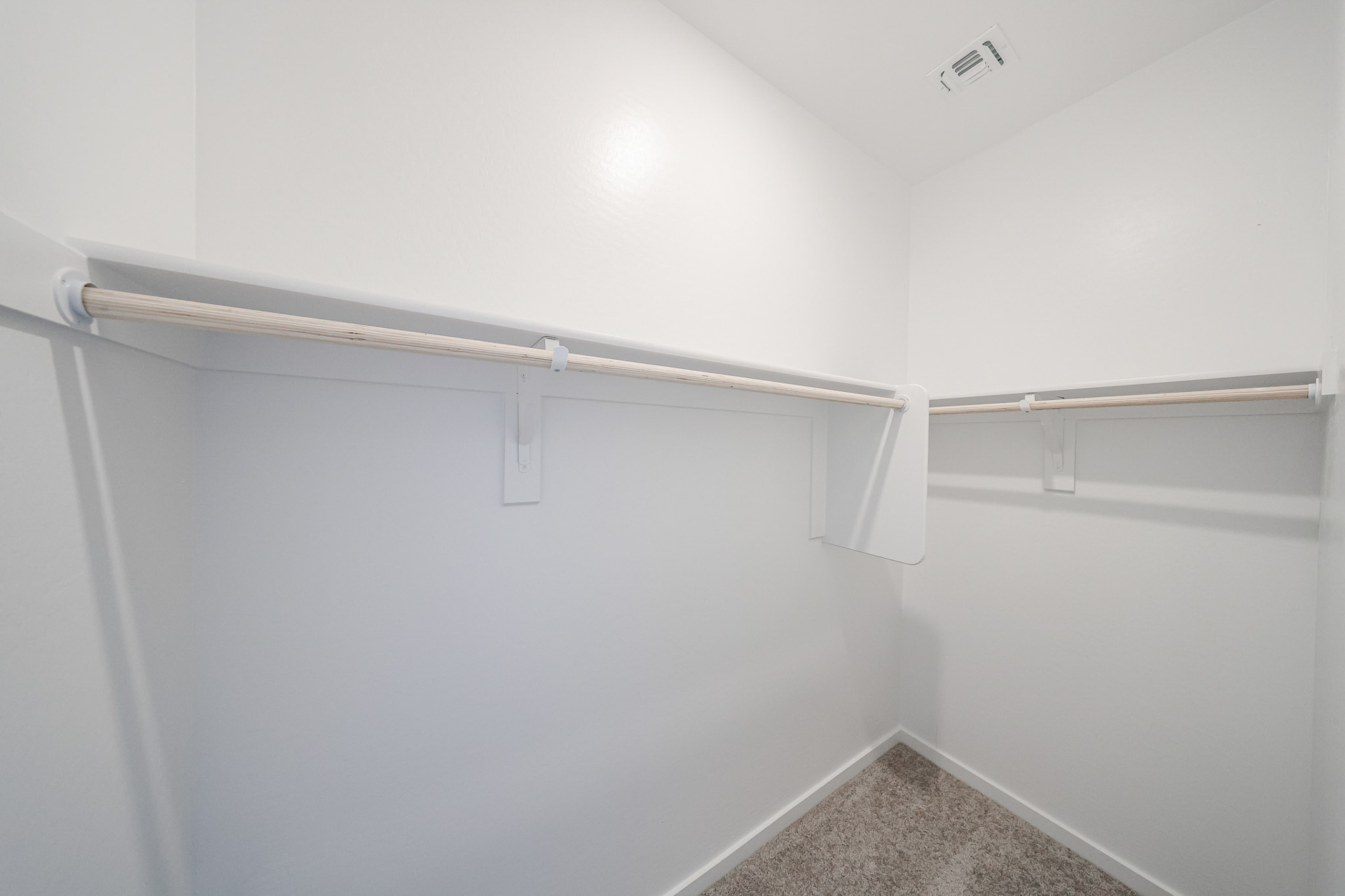 A white wall with a metal bar.