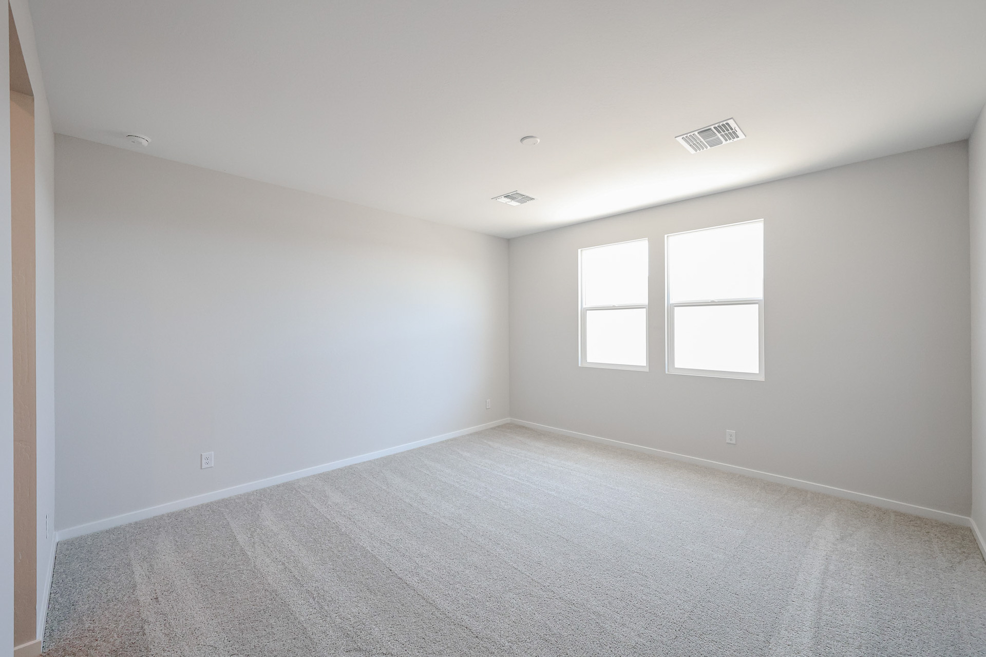 A room with a carpet and windows.