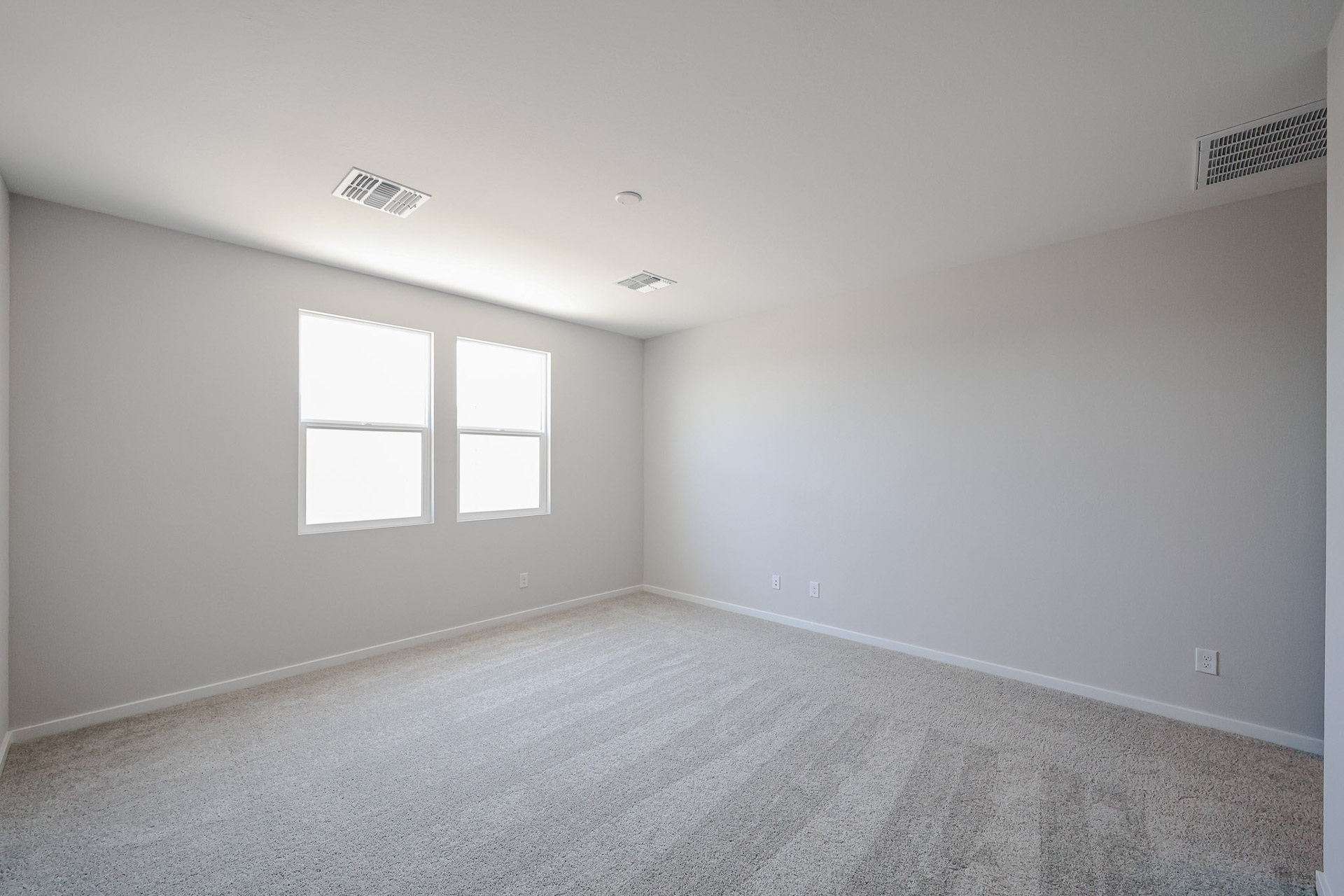 A room with a carpet and windows.