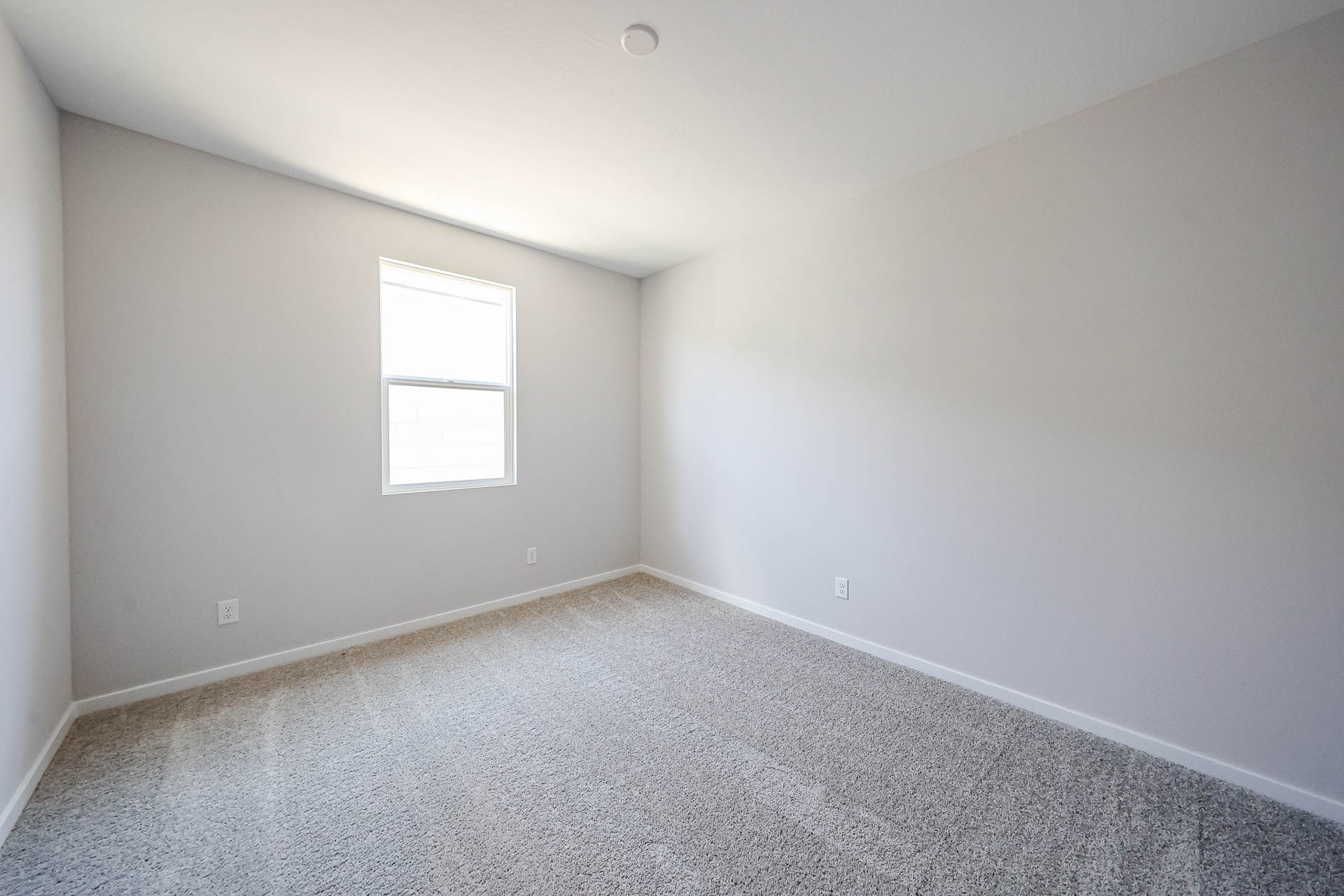 A room with a white wall and a window.