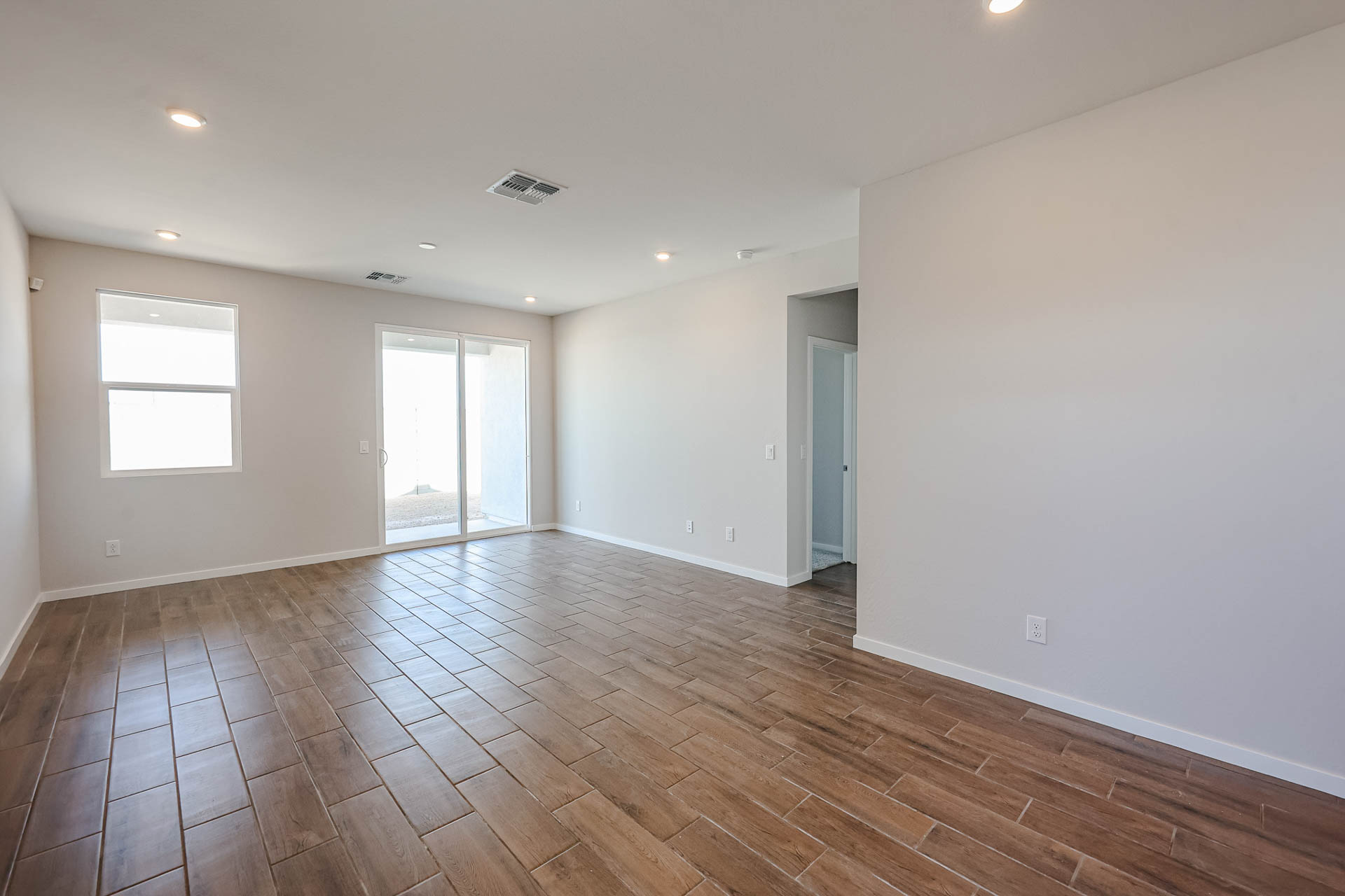 A room with a wood floor and windows.