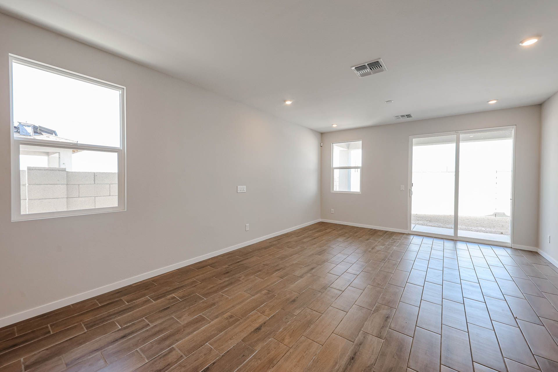 A room with windows and wood floor.