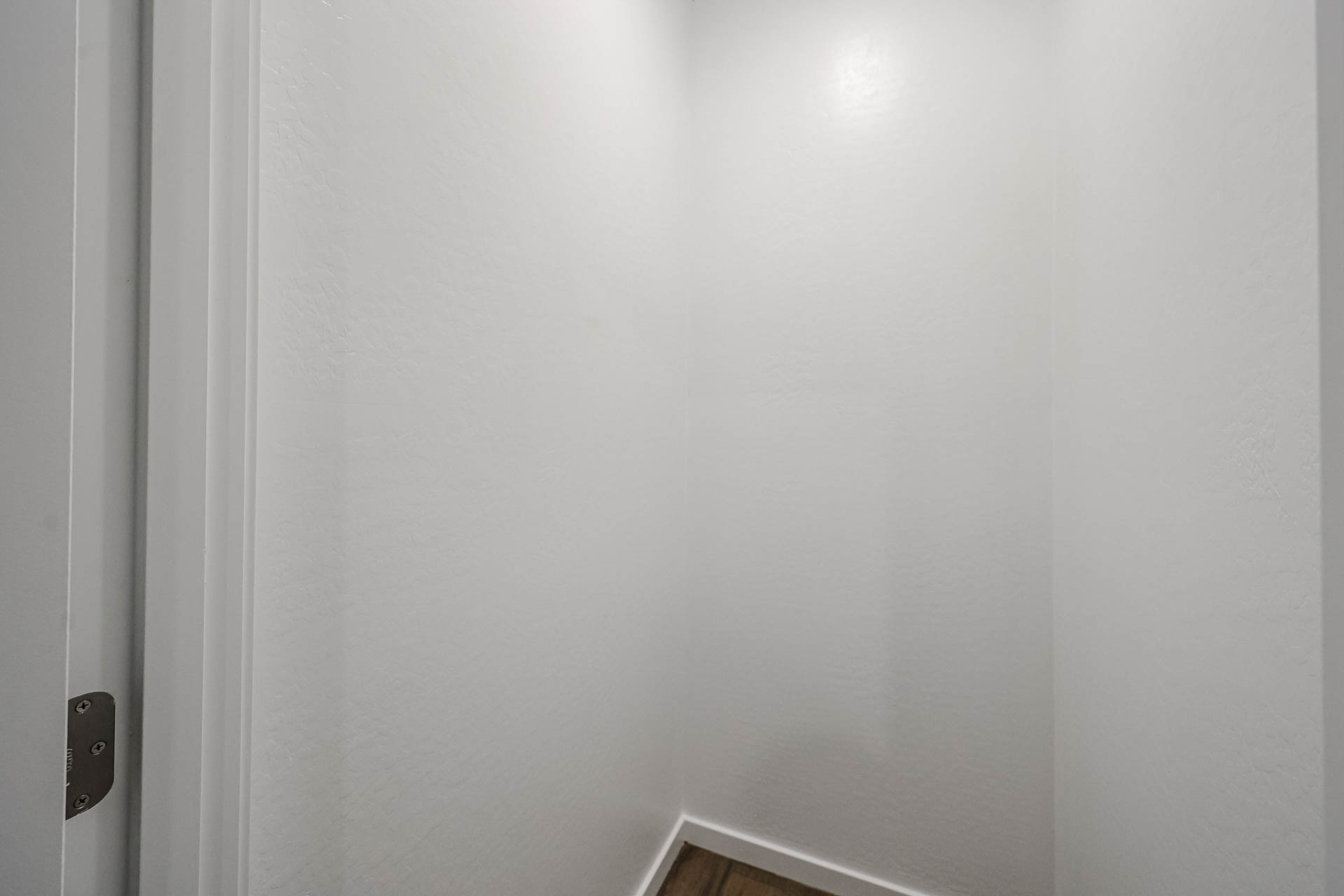 A white wall with a light switch.