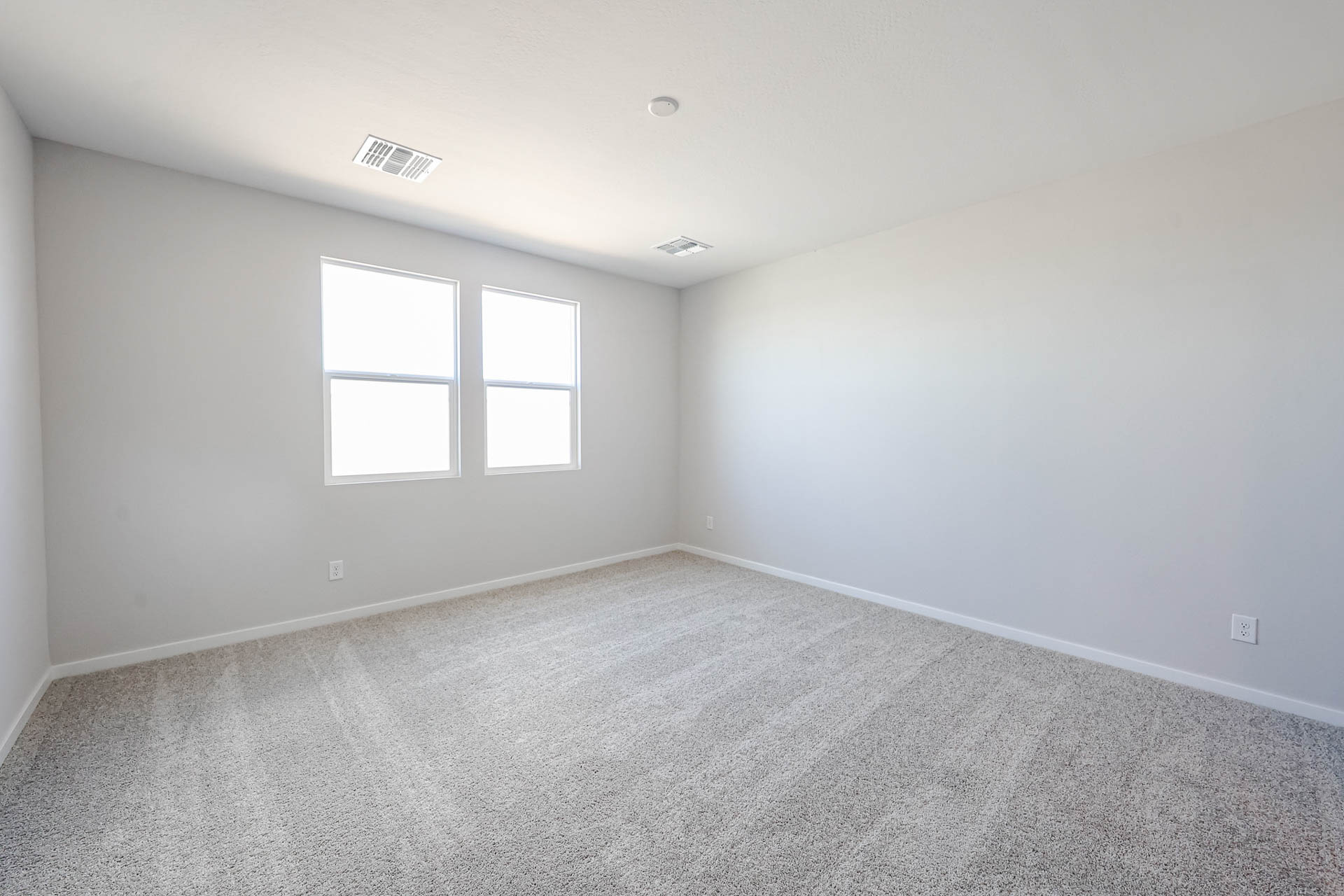 A room with a carpet and windows.