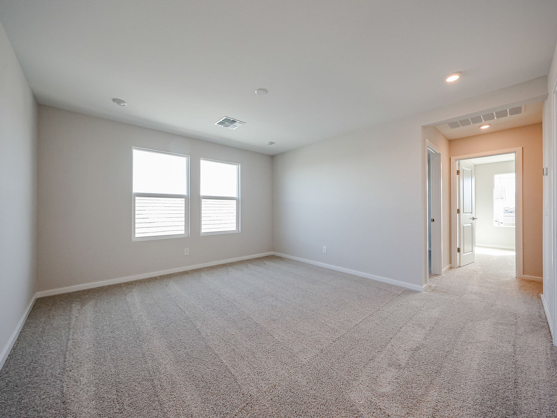 A room with a carpet and windows.
