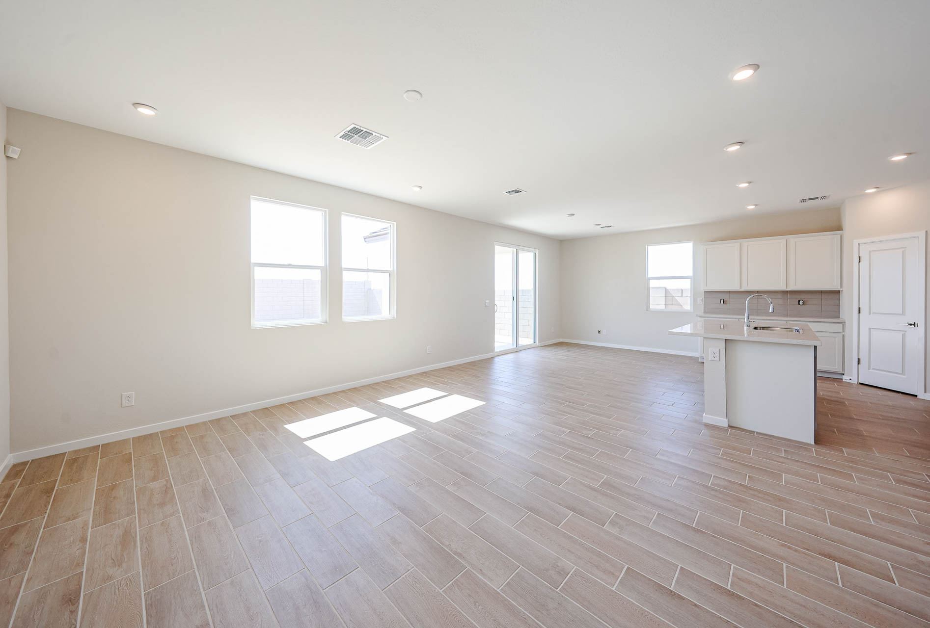 A large empty room with white cabinets.