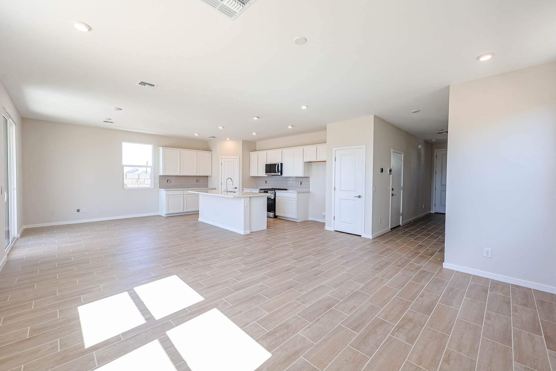 A large empty room with white cabinets.