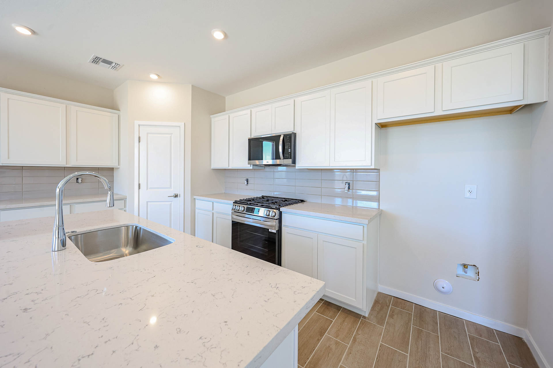 A kitchen with white cabinets.