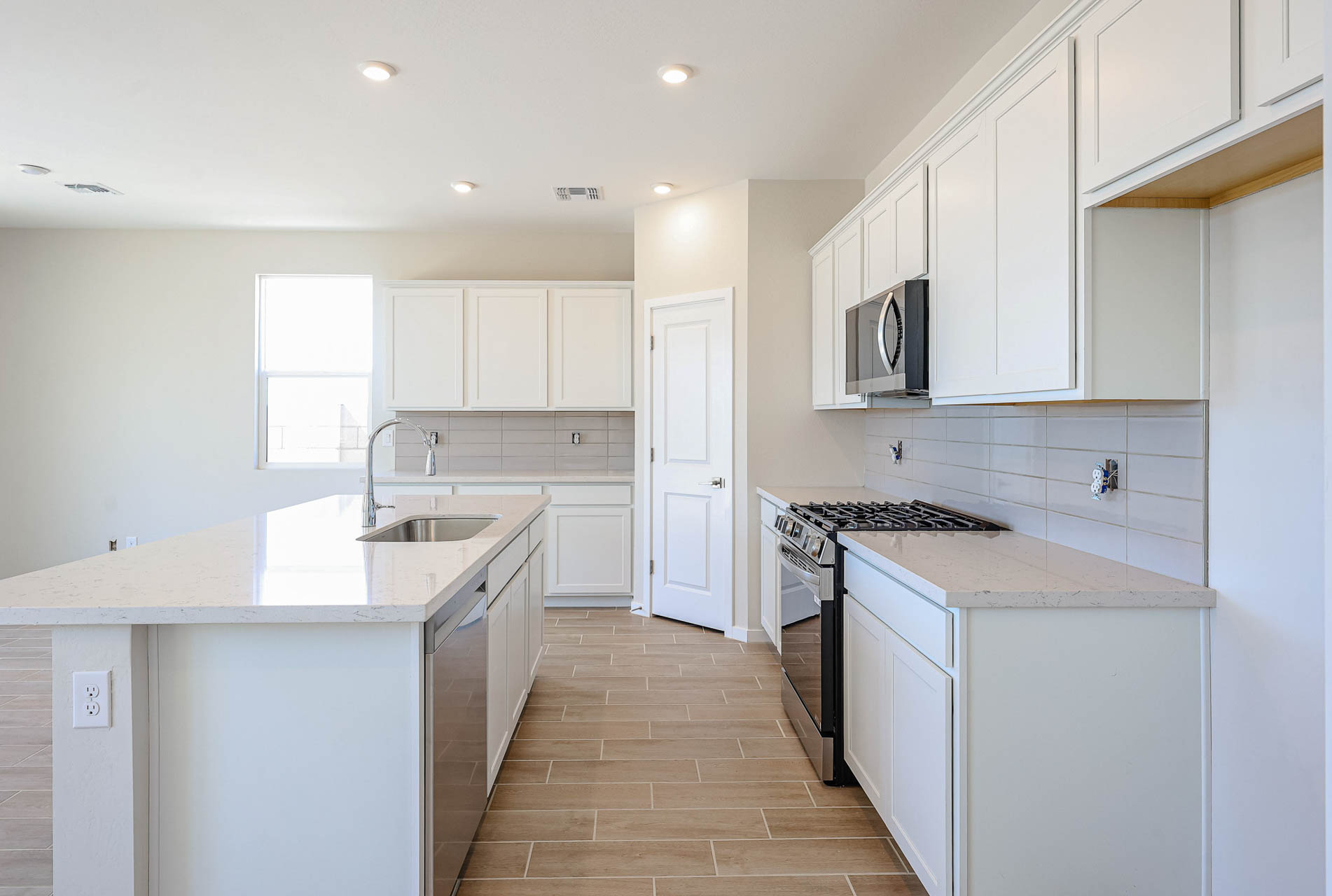 A kitchen with white cabinets.