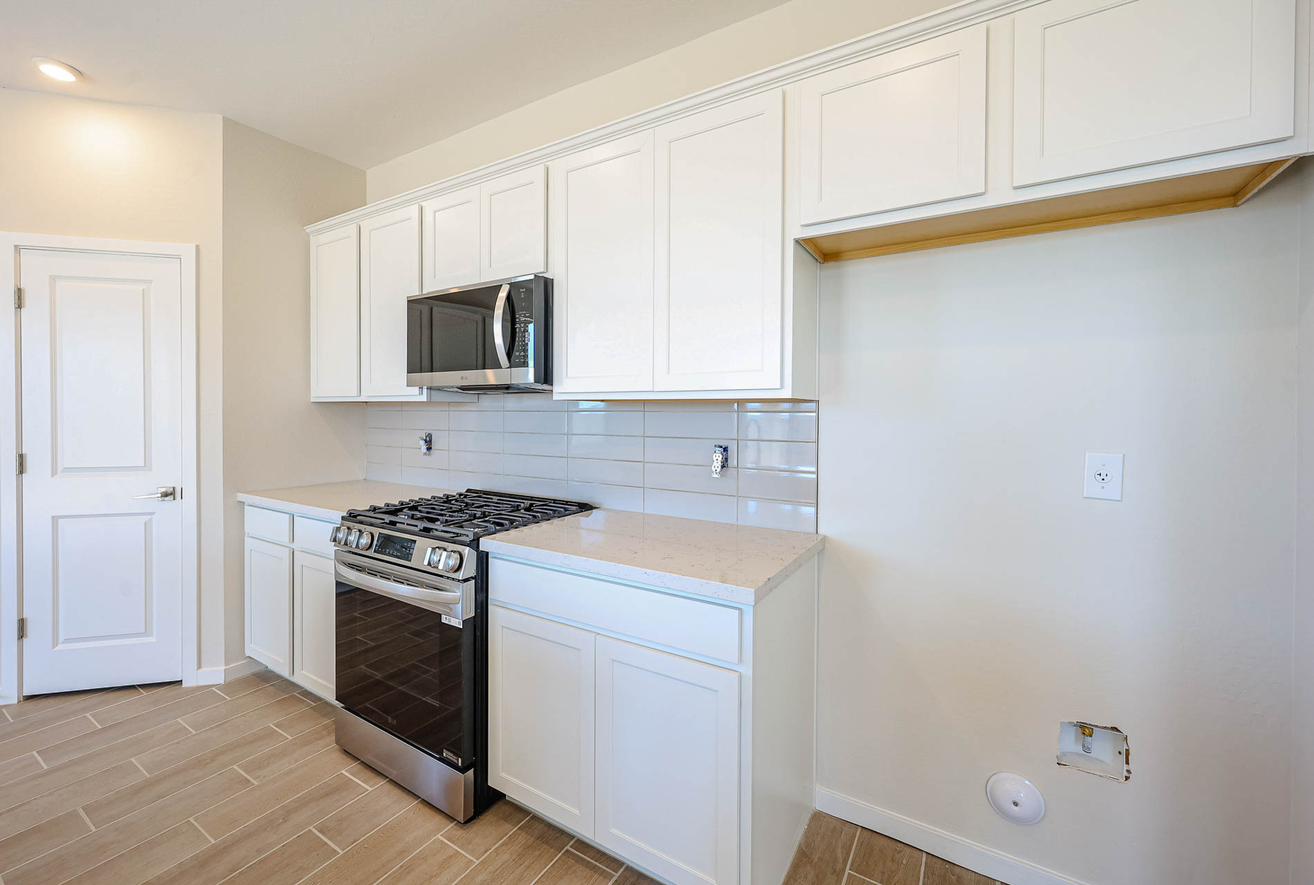A kitchen with white cabinets.