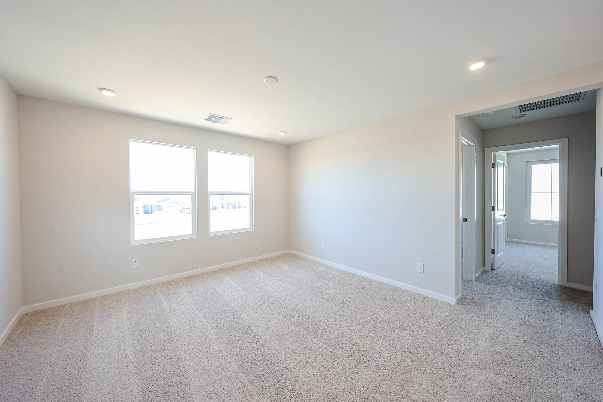 A room with a carpet and windows.