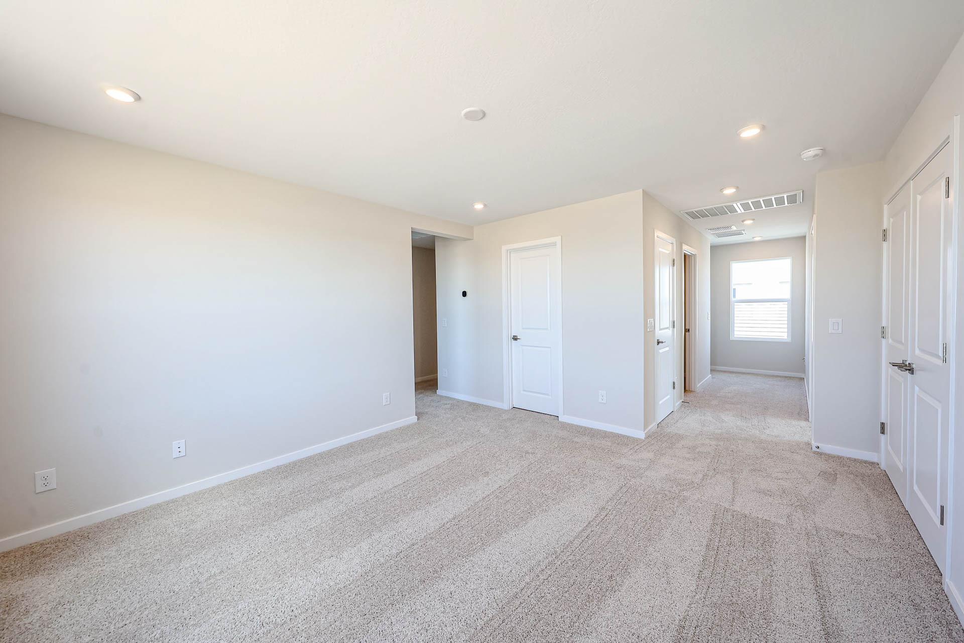 A long hallway with white doors.