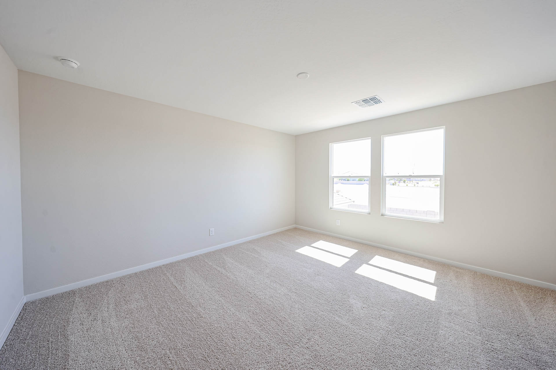 A room with a carpet and windows.