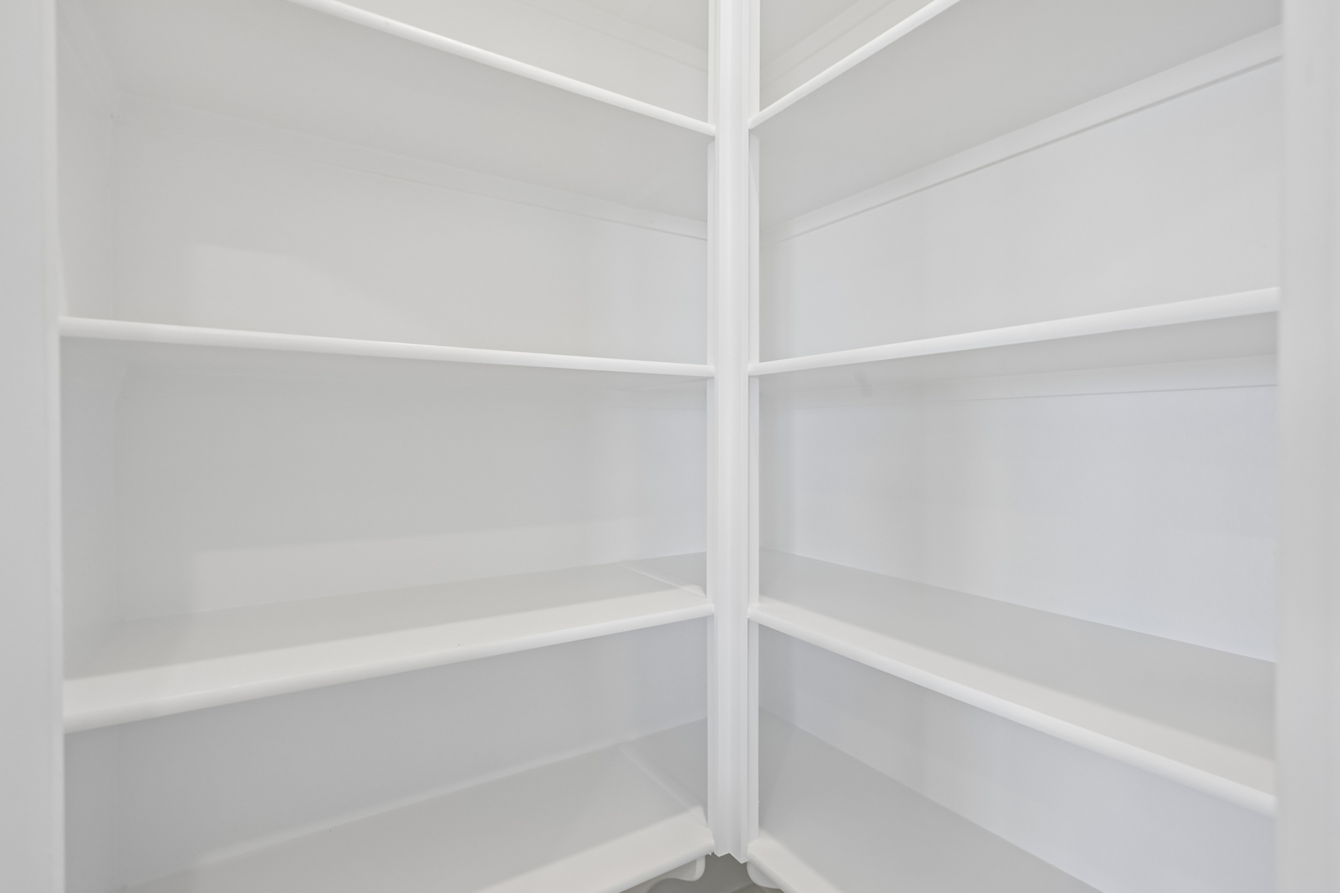 A white shelf with a white wall.