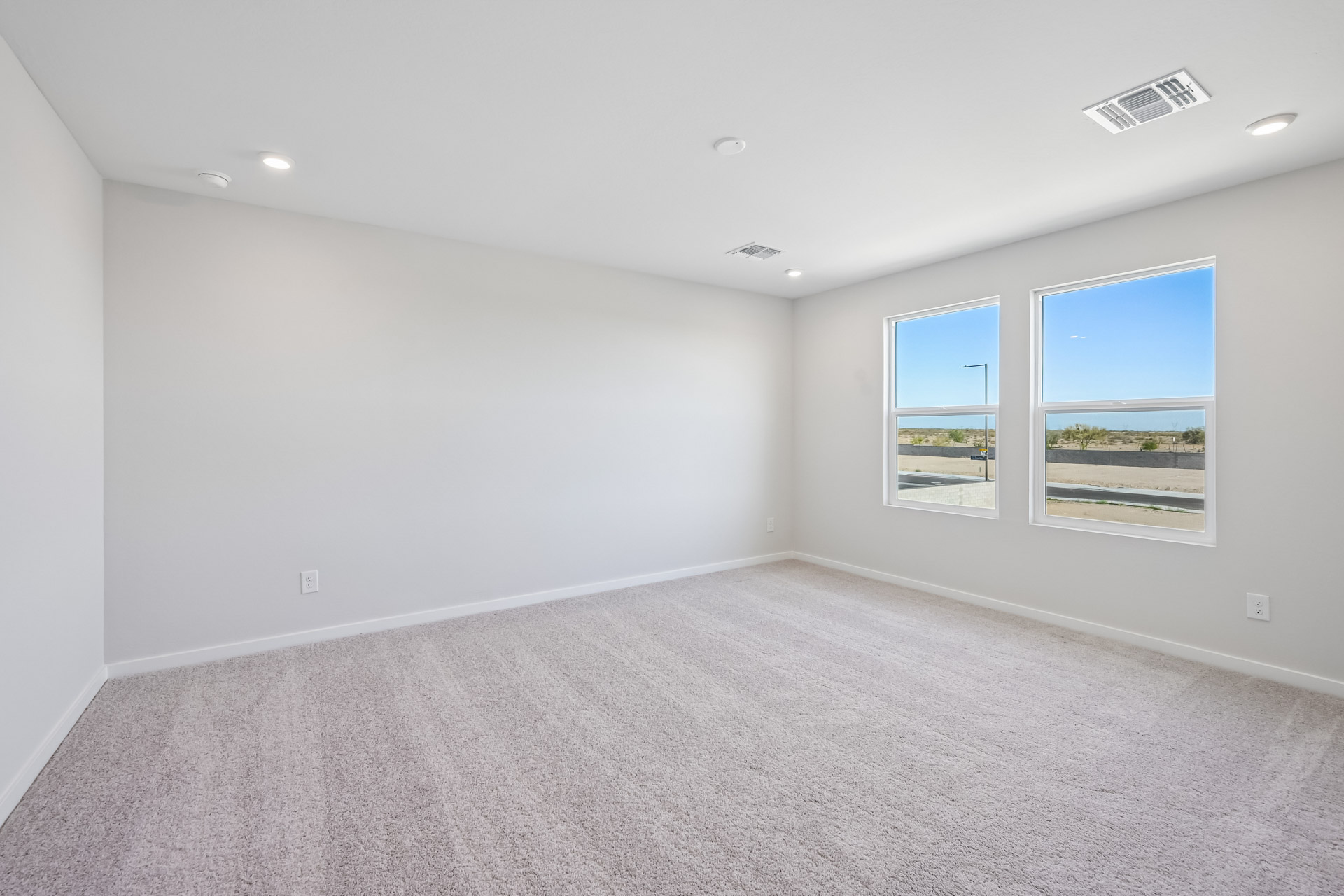 A room with a carpet and windows.