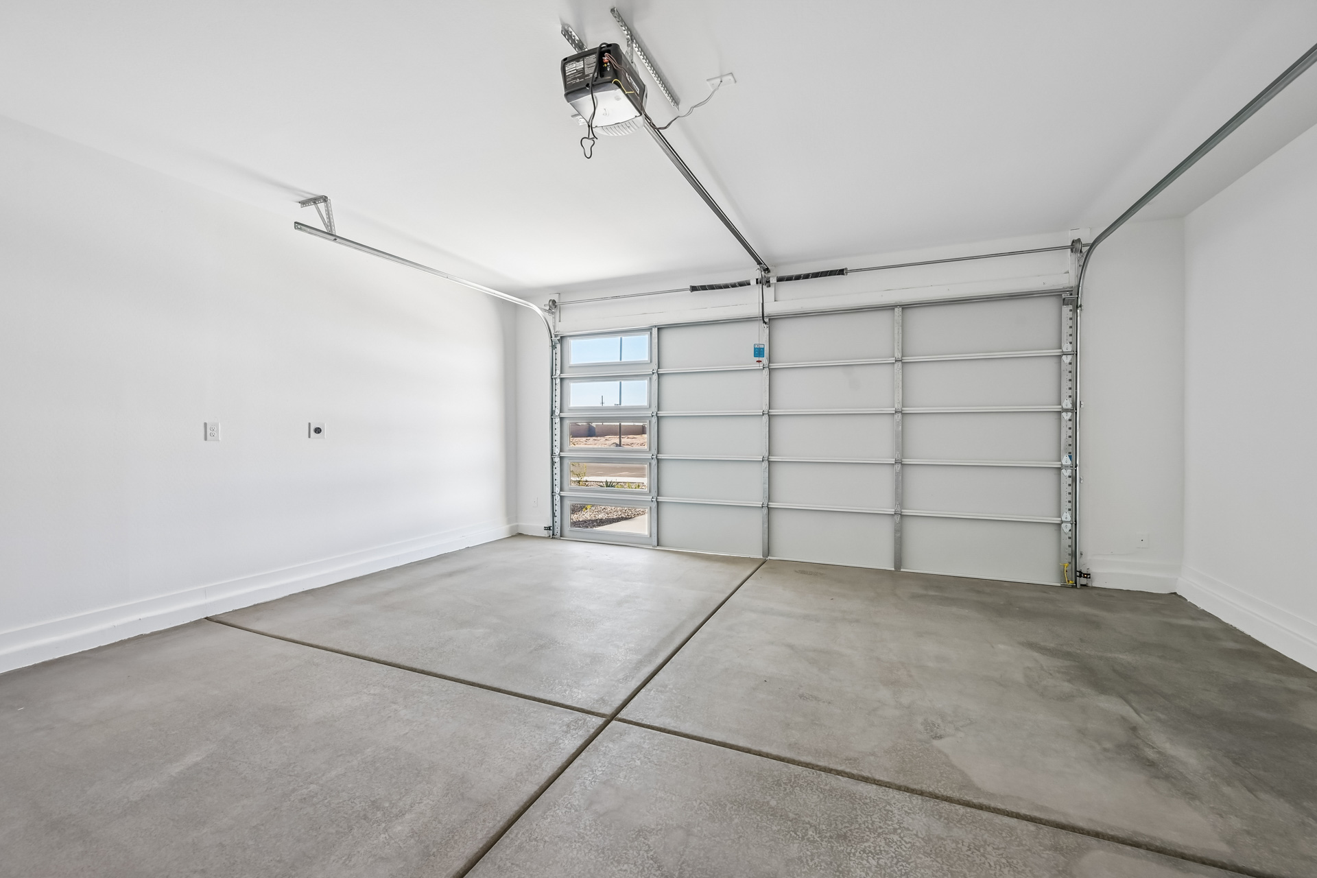 A room with a white wall and a metal gate.