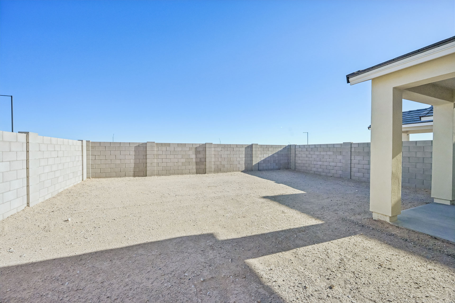 A concrete wall with a building in the background.
