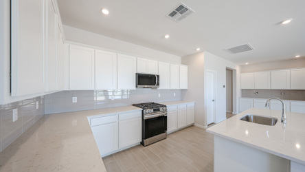 A kitchen with white cabinets.