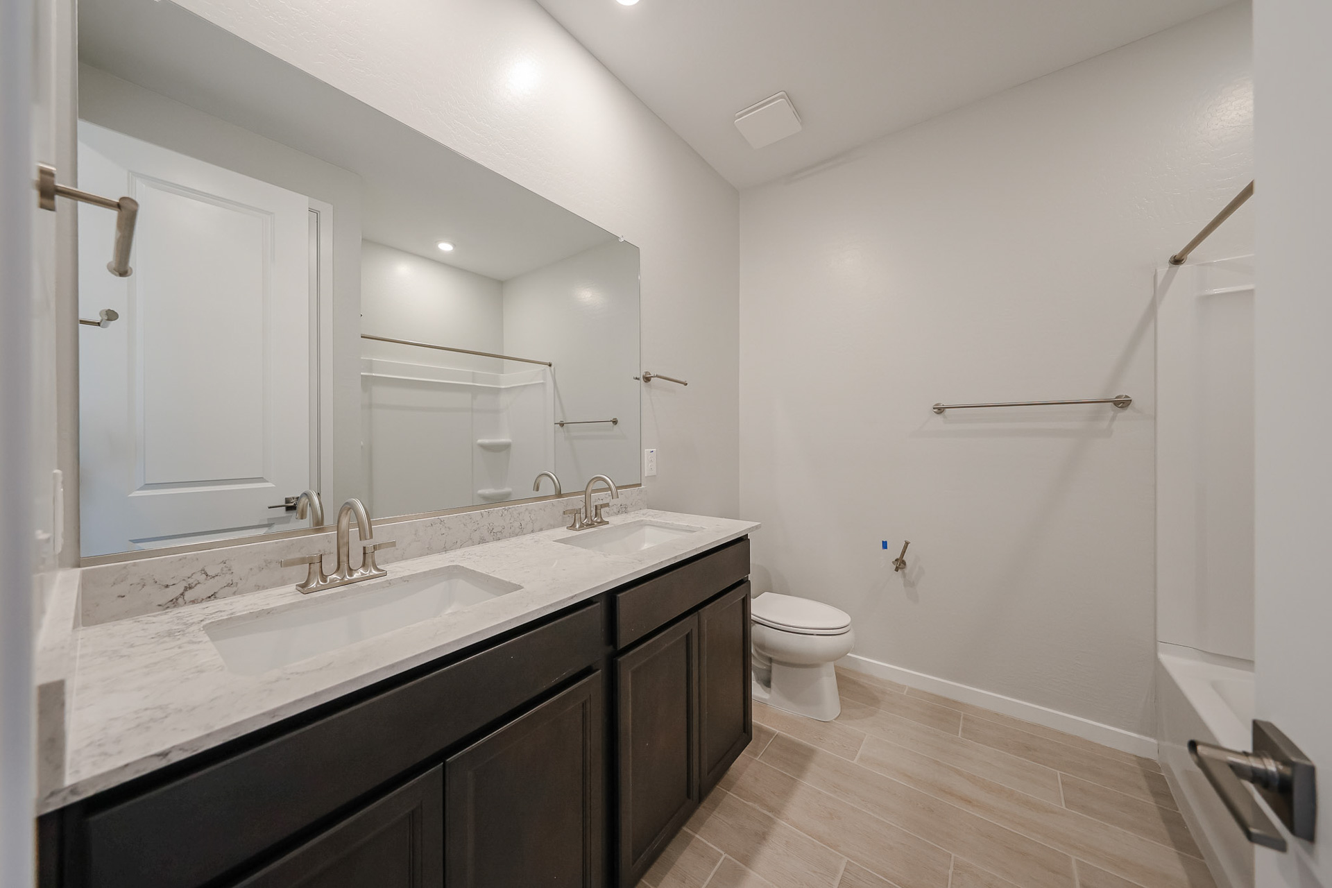 A bathroom with a sink toilet and mirror.