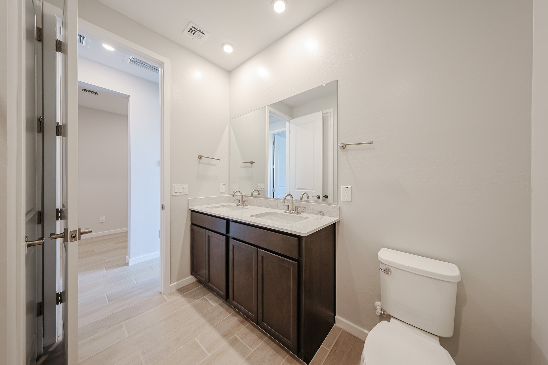 A bathroom with a sink toilet and mirror.