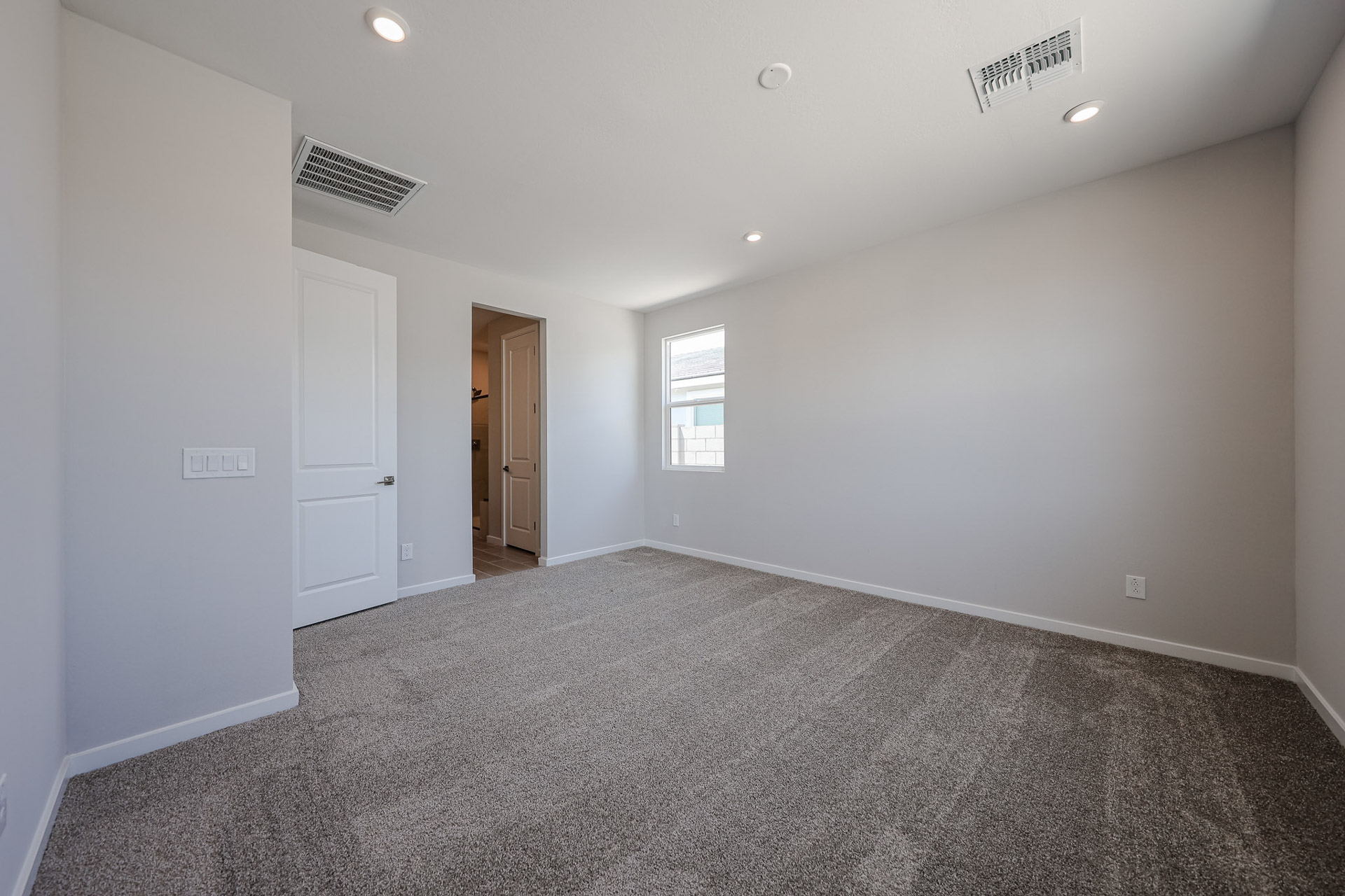 A room with a carpet and a door.