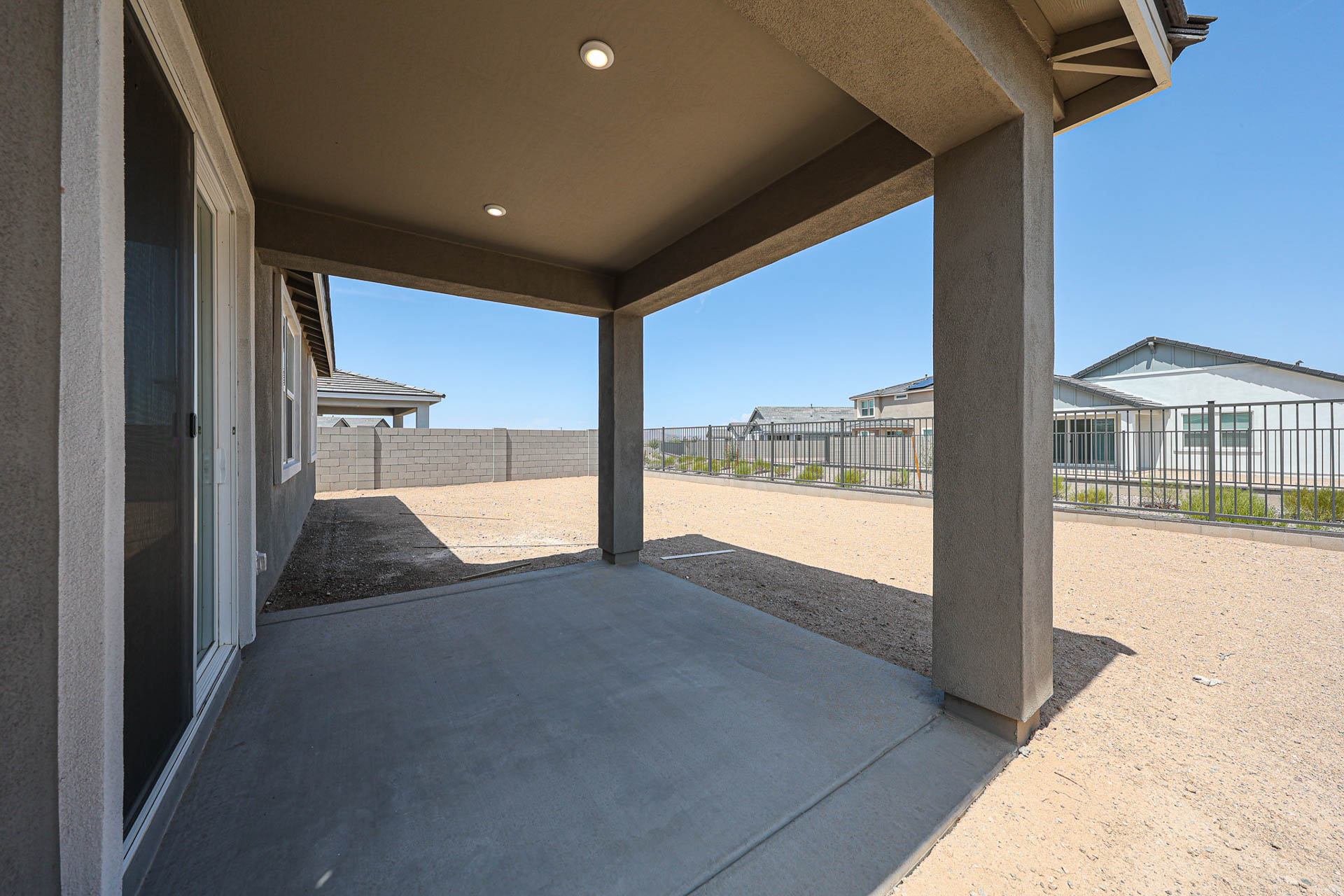 A walkway with pillars and a fence.