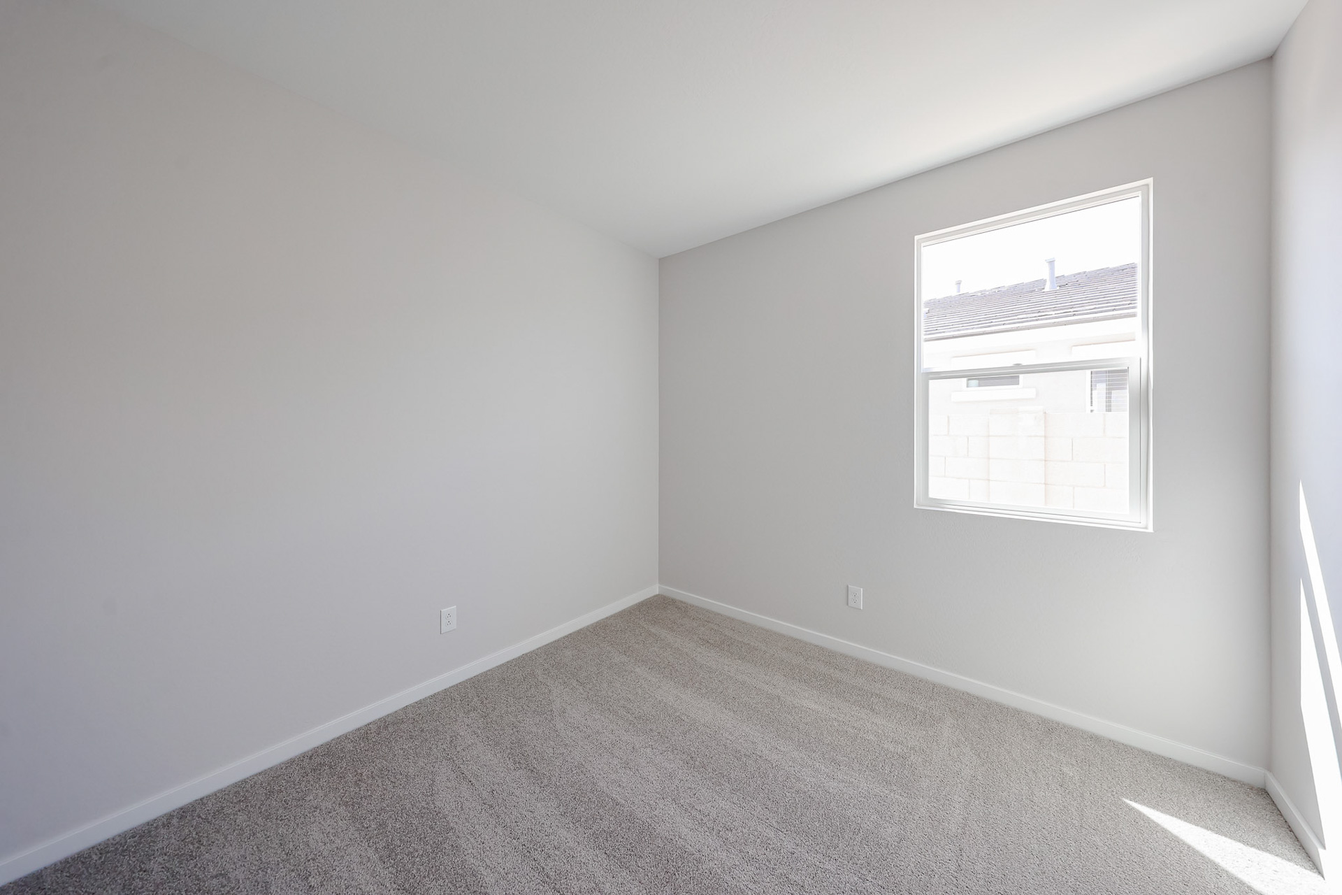 A room with a white wall and a window.