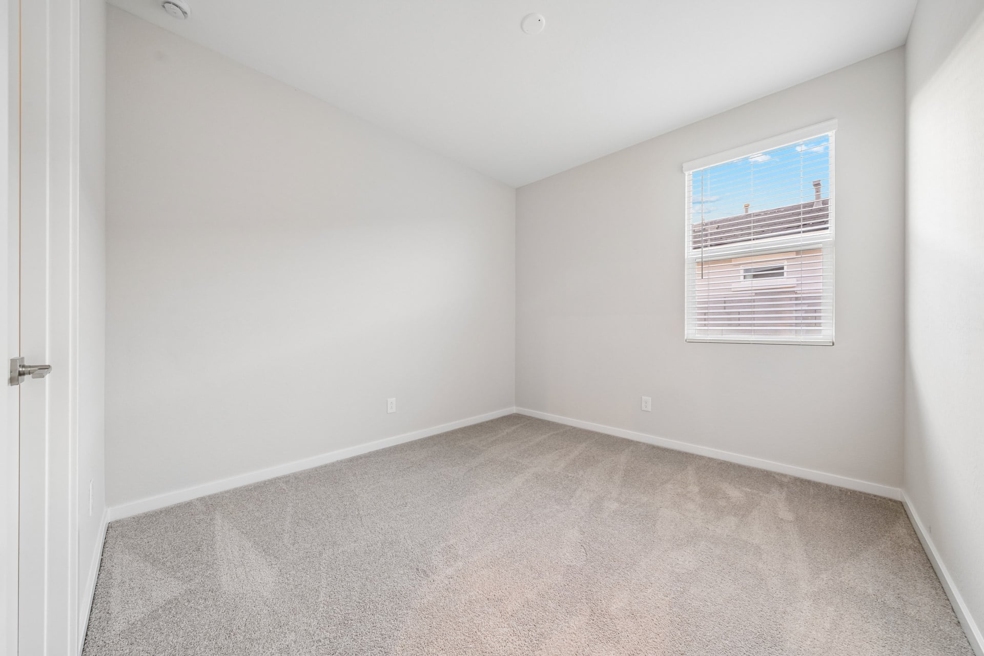 A room with a carpet and a poster on the wall.