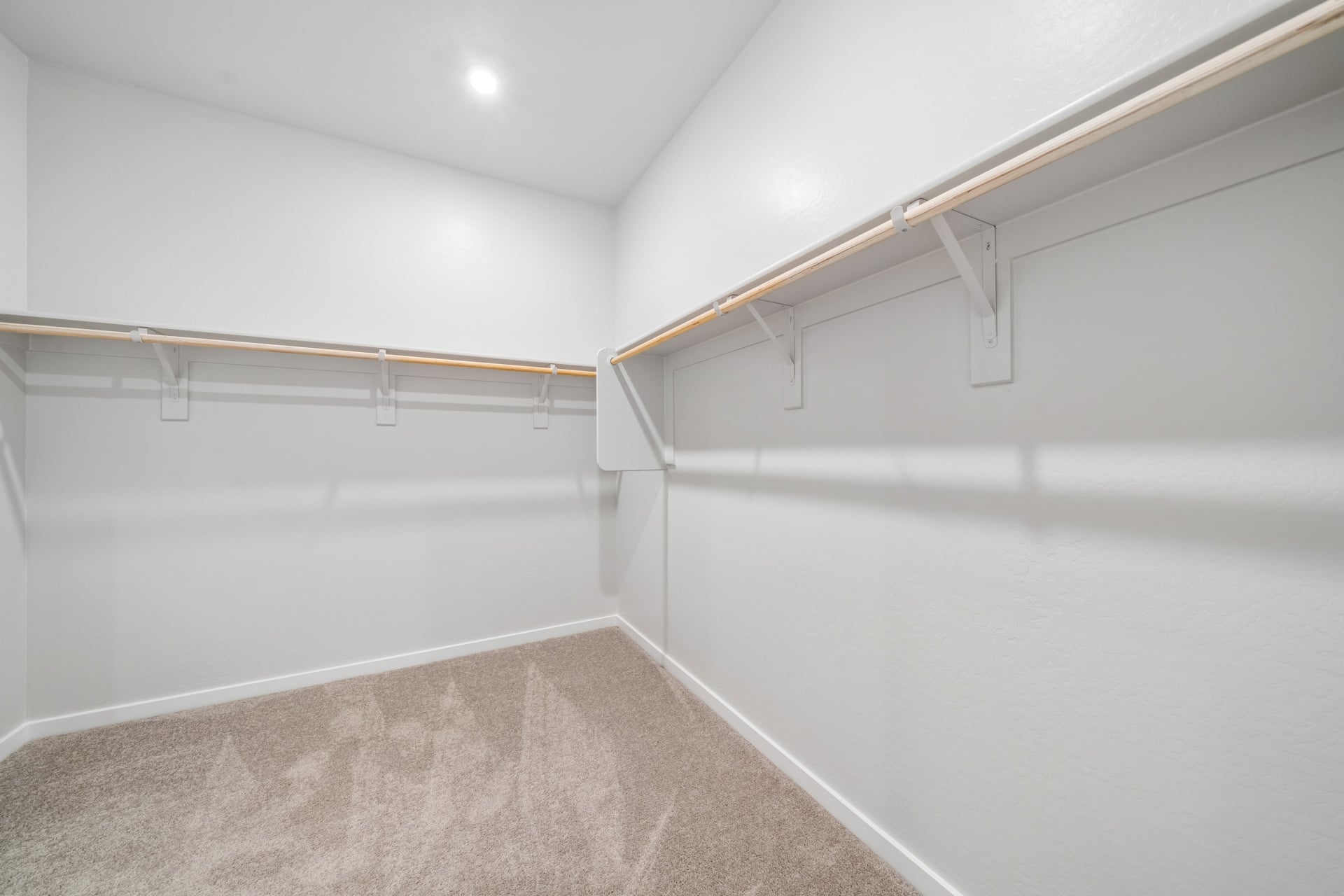 A white hallway with a metal railing.