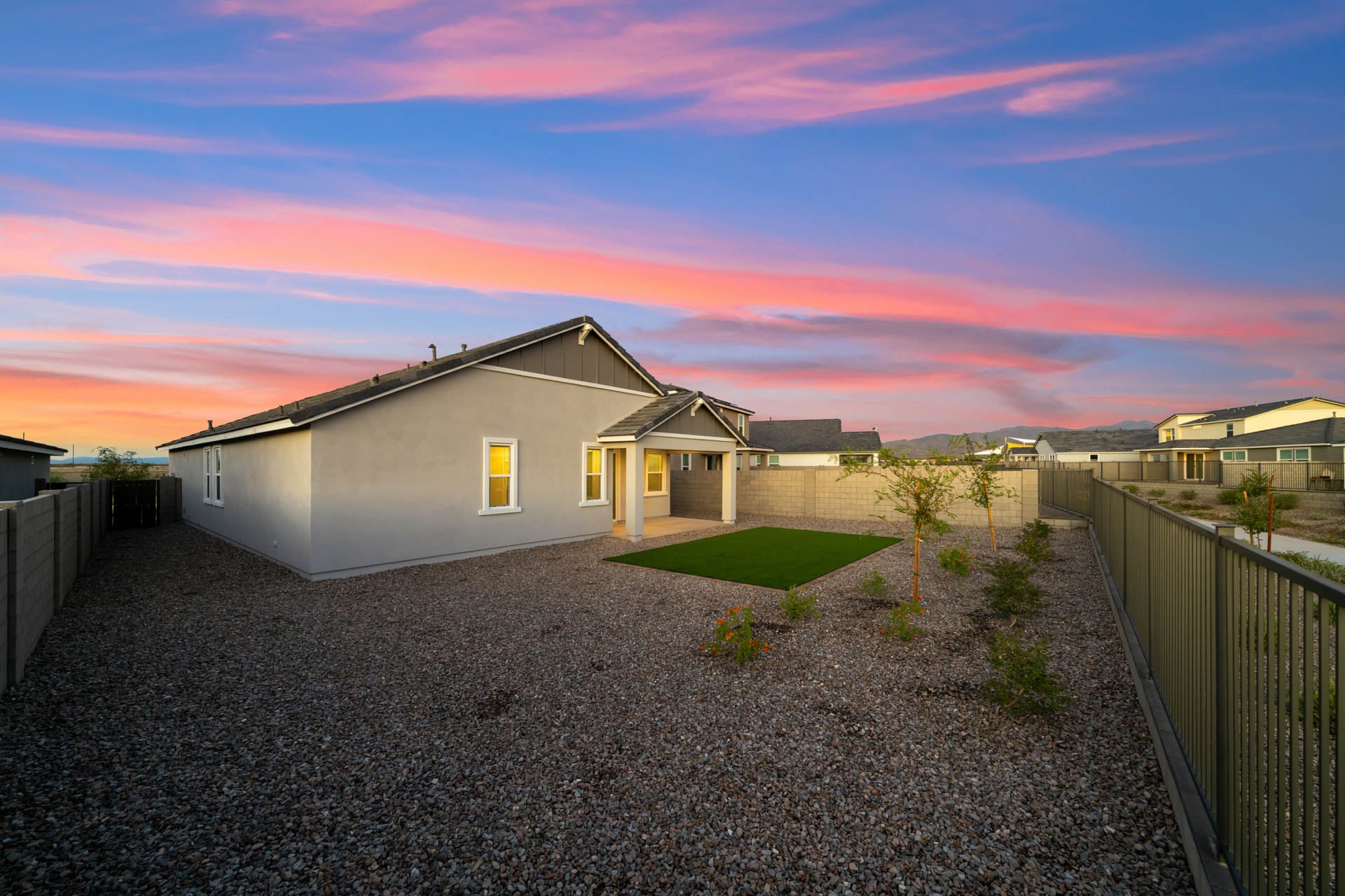 A house with a fence and a dirt road.
