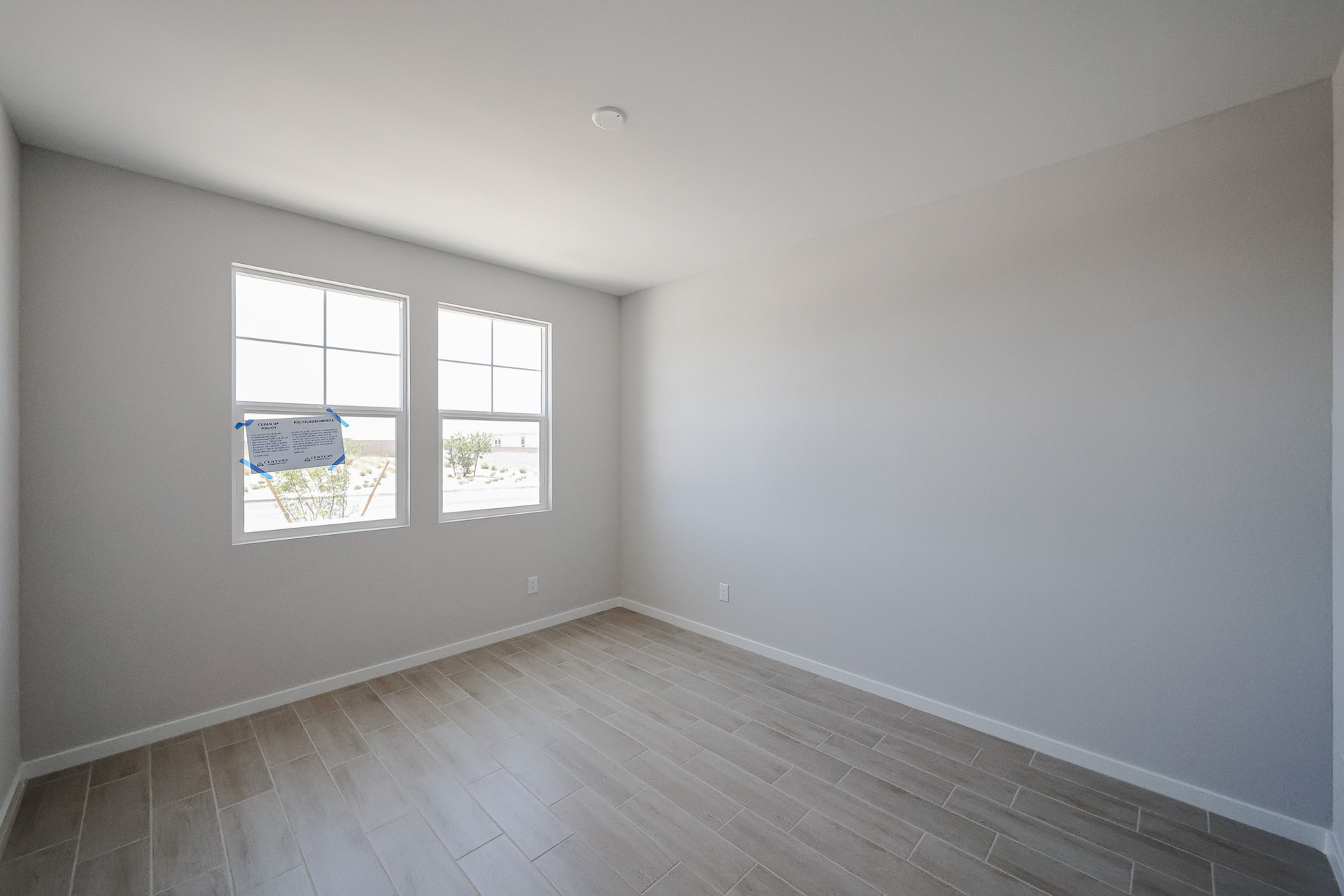 A room with a window and a wood floor.