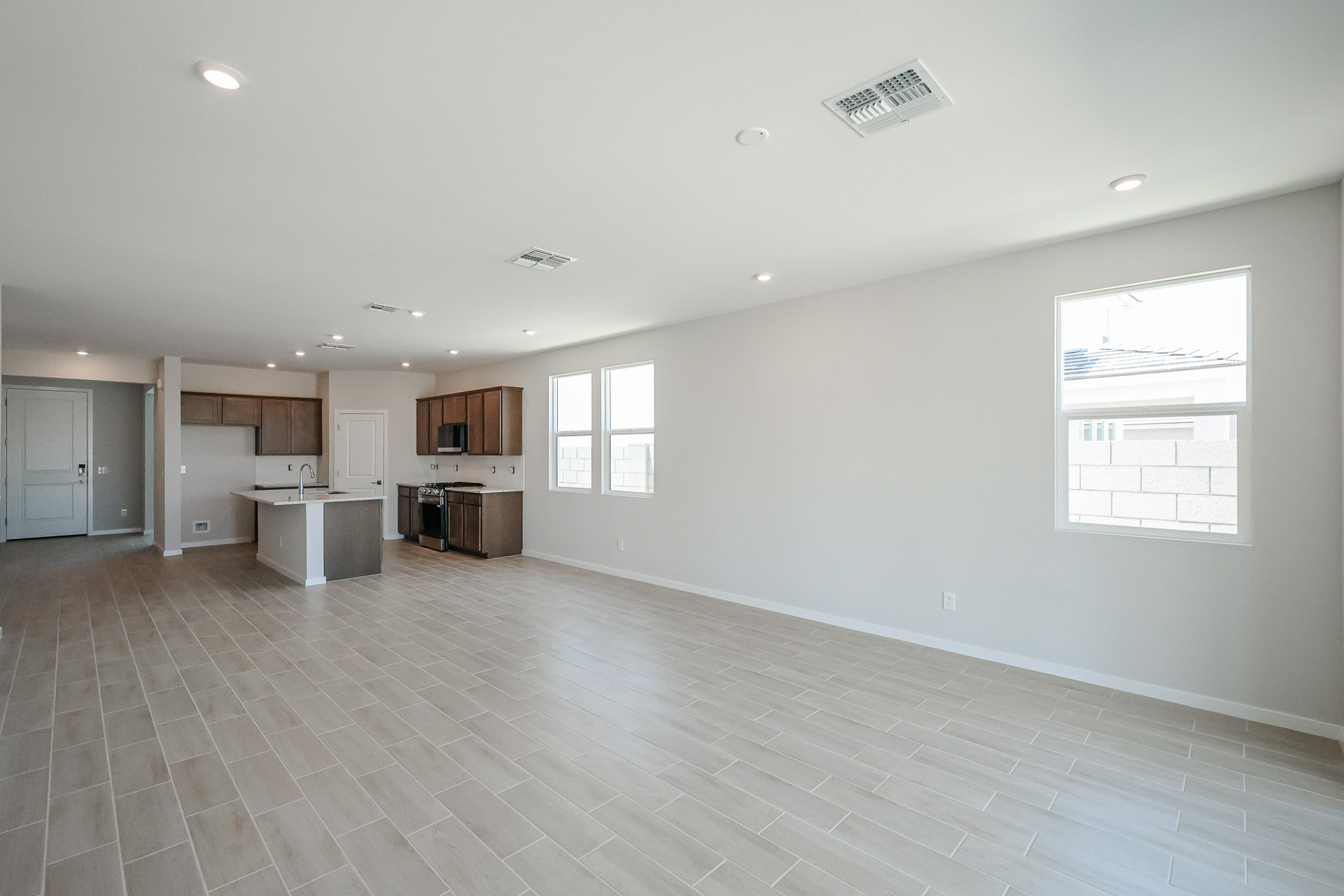 A large empty room with a wood floor and white walls.
