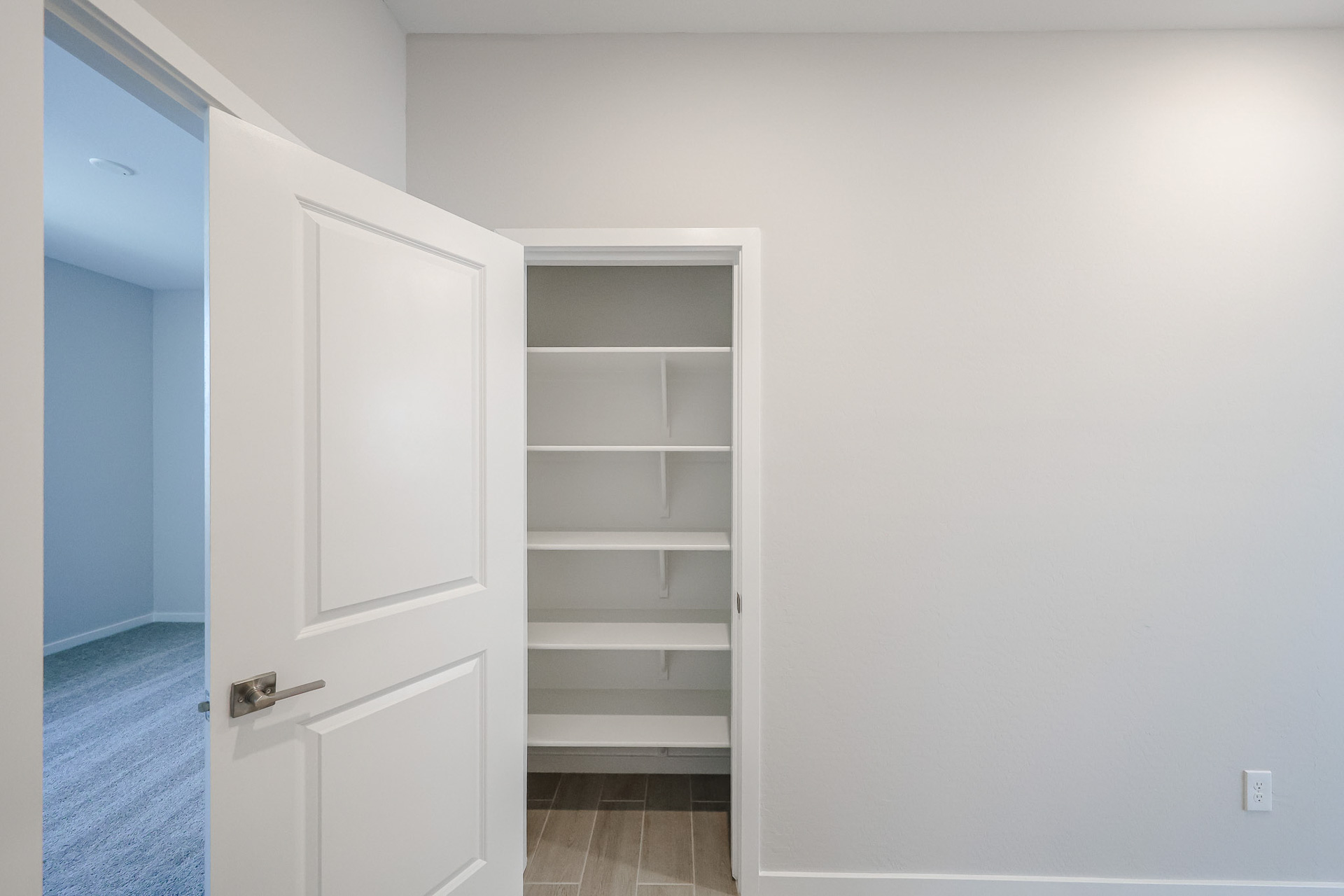 A white door with a white shelf.