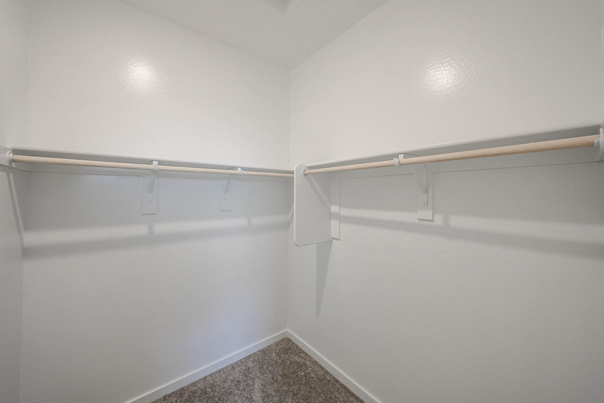 A white wall with a metal bar.