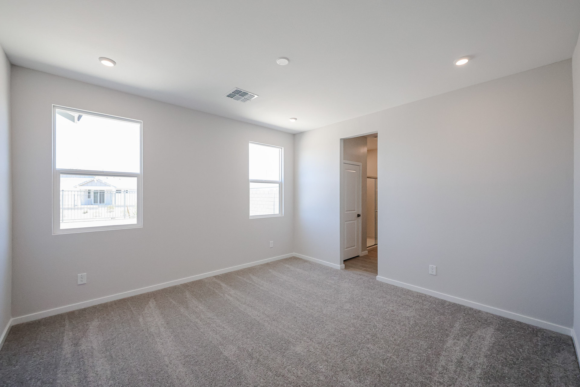 A room with a carpet and windows.