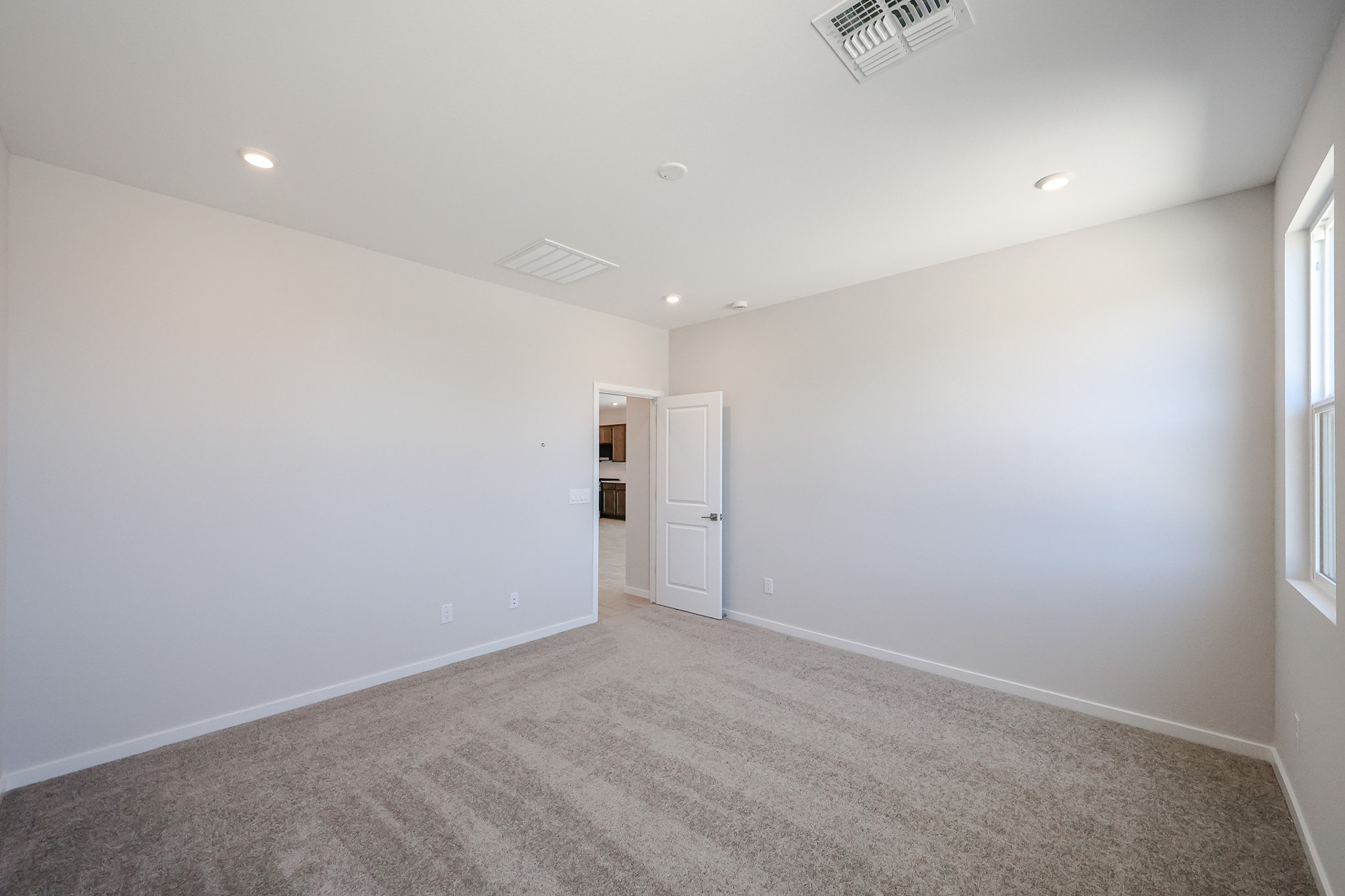 A room with a carpet and a door.