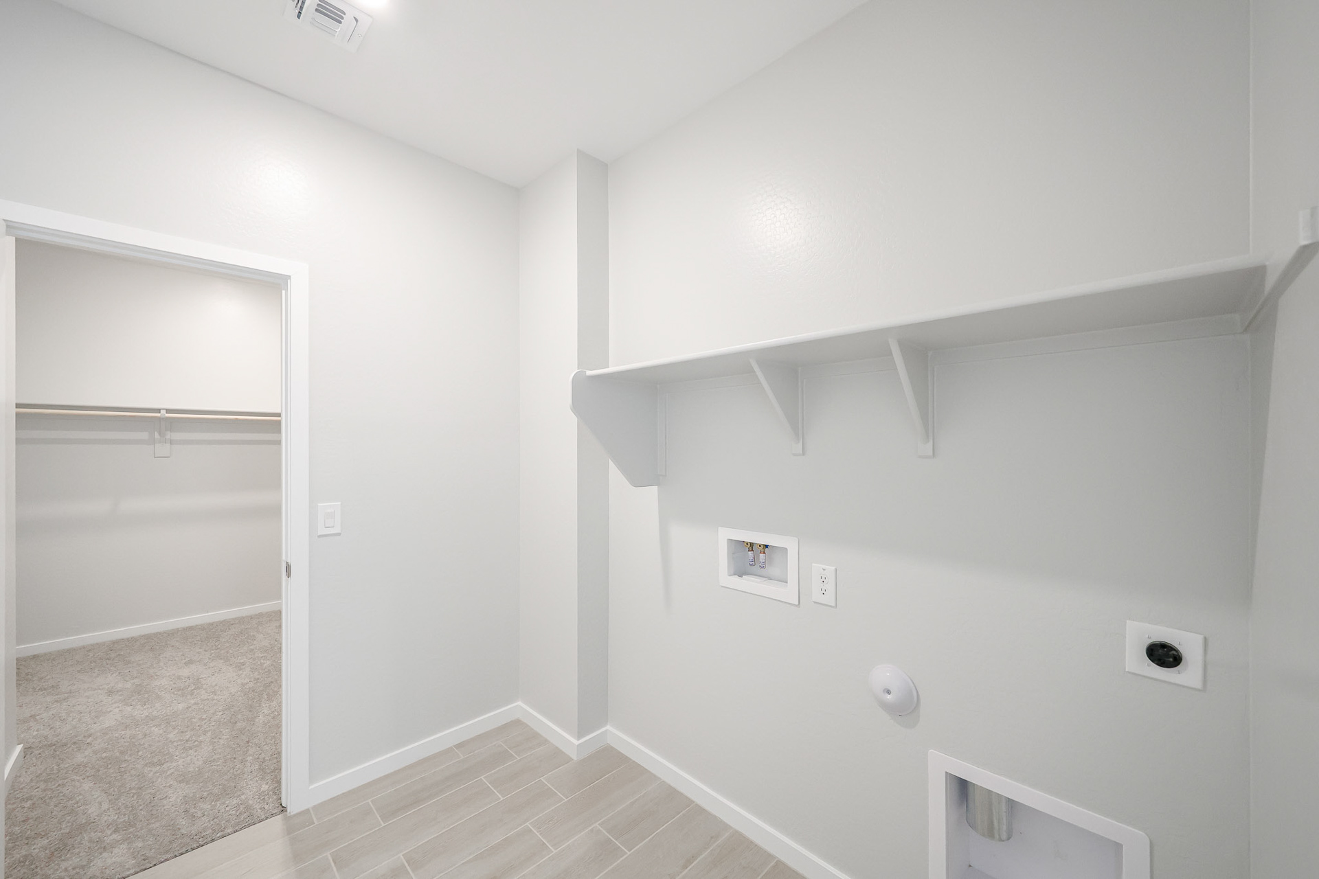 A white room with a shower and a glass door.