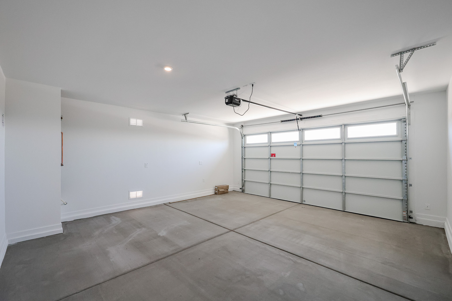 A room with a white wall and a metal door.