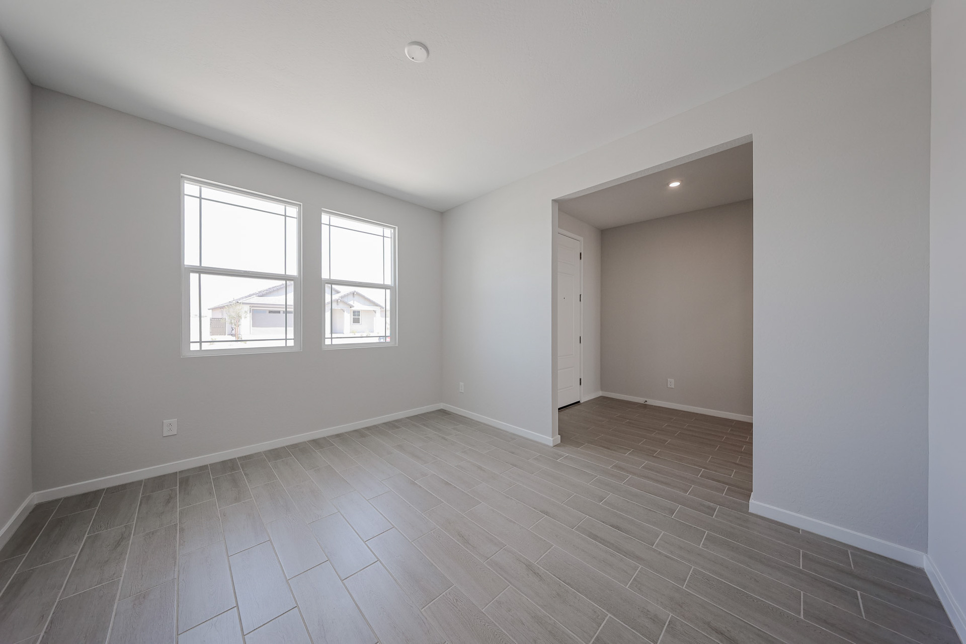 A room with a wood floor and windows.