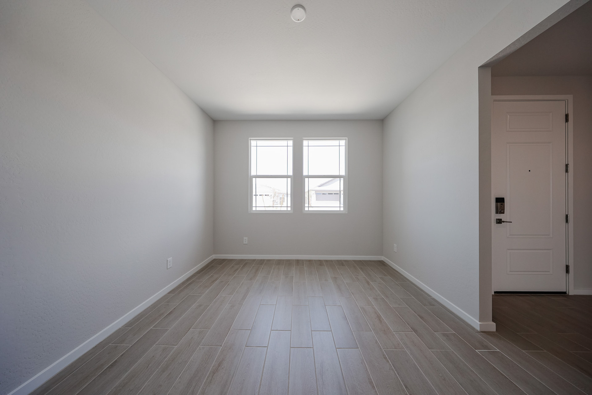 A room with a wood floor and a wood floor with a white door.