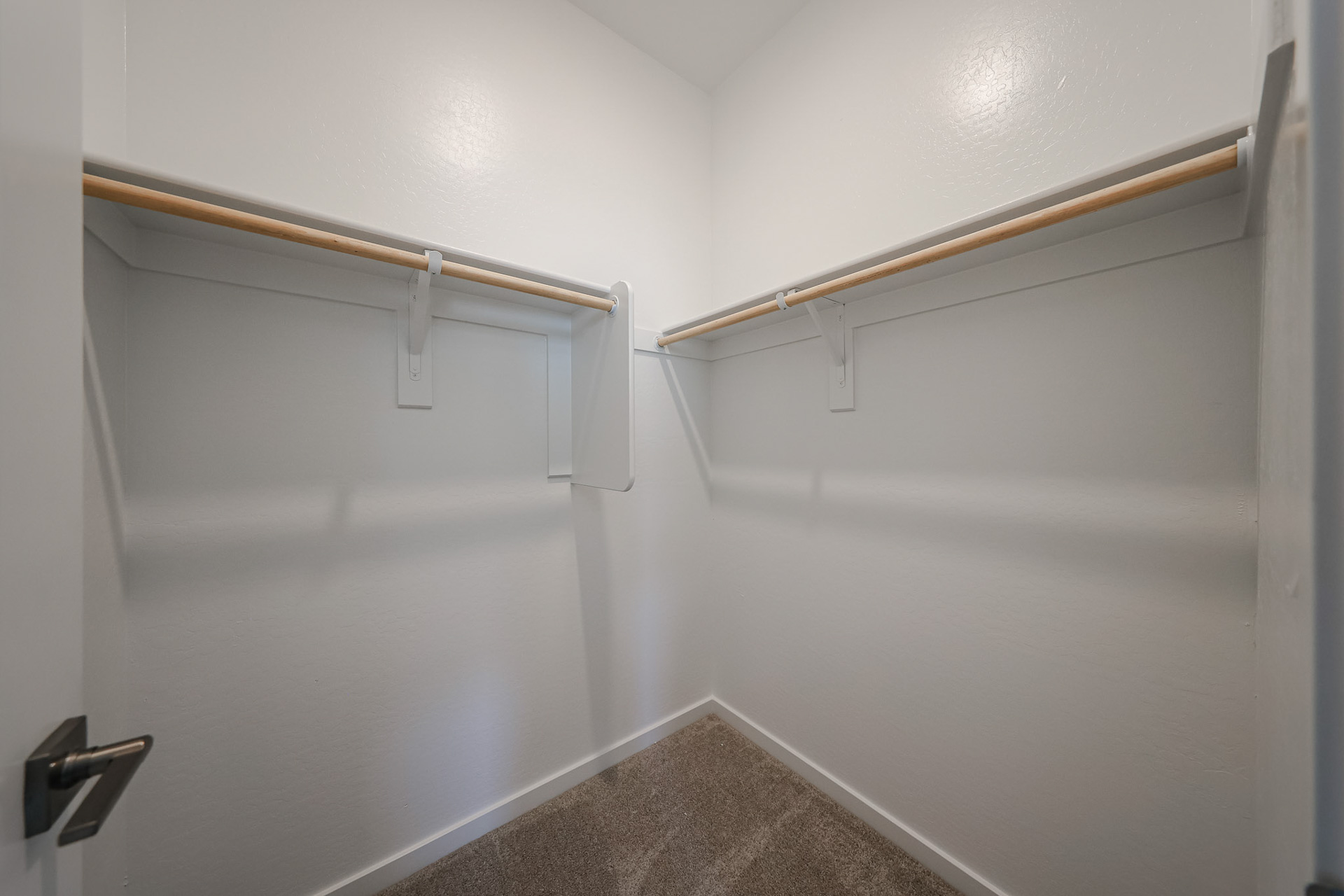 A white wall with a metal bar.