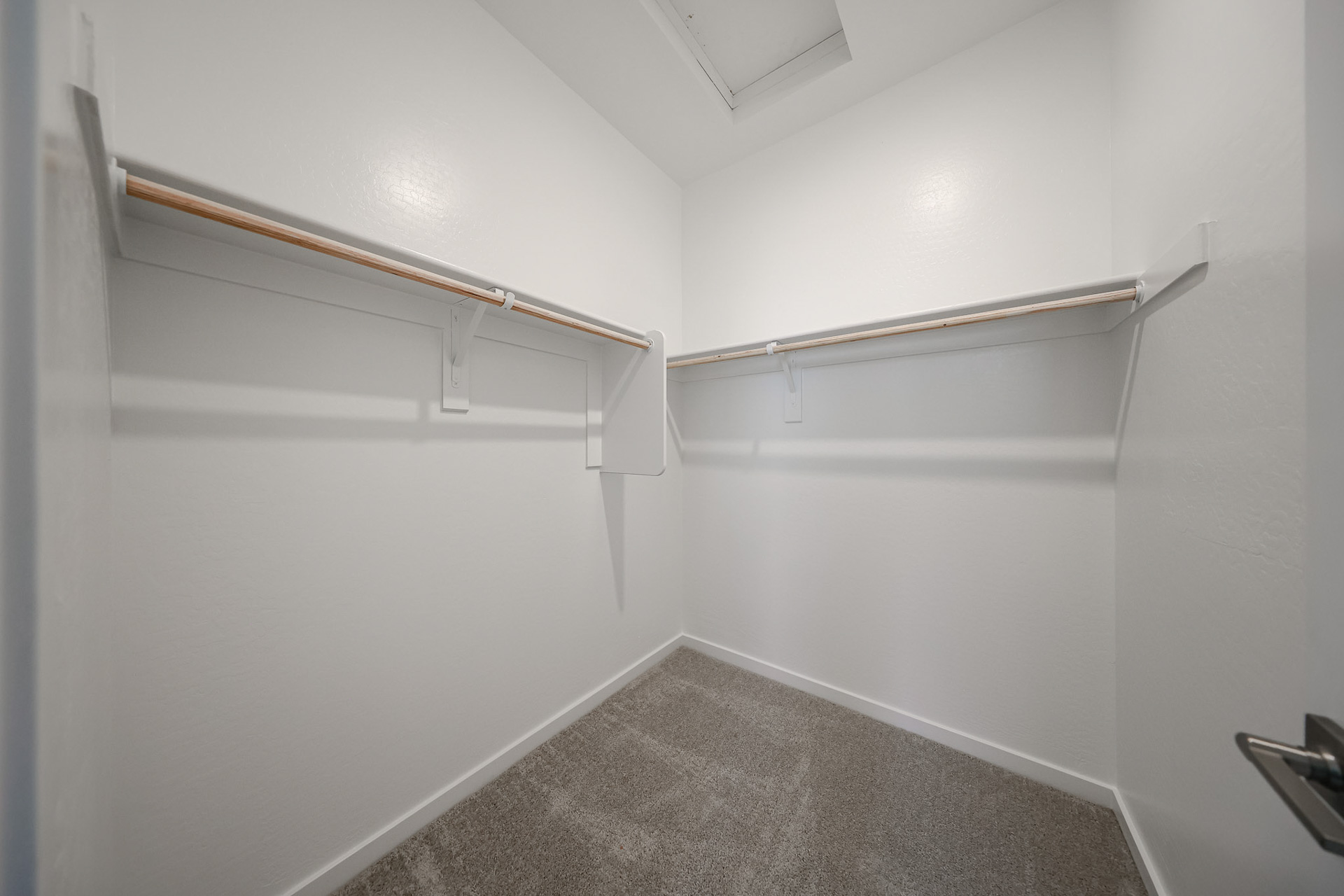 A white hallway with a metal railing.