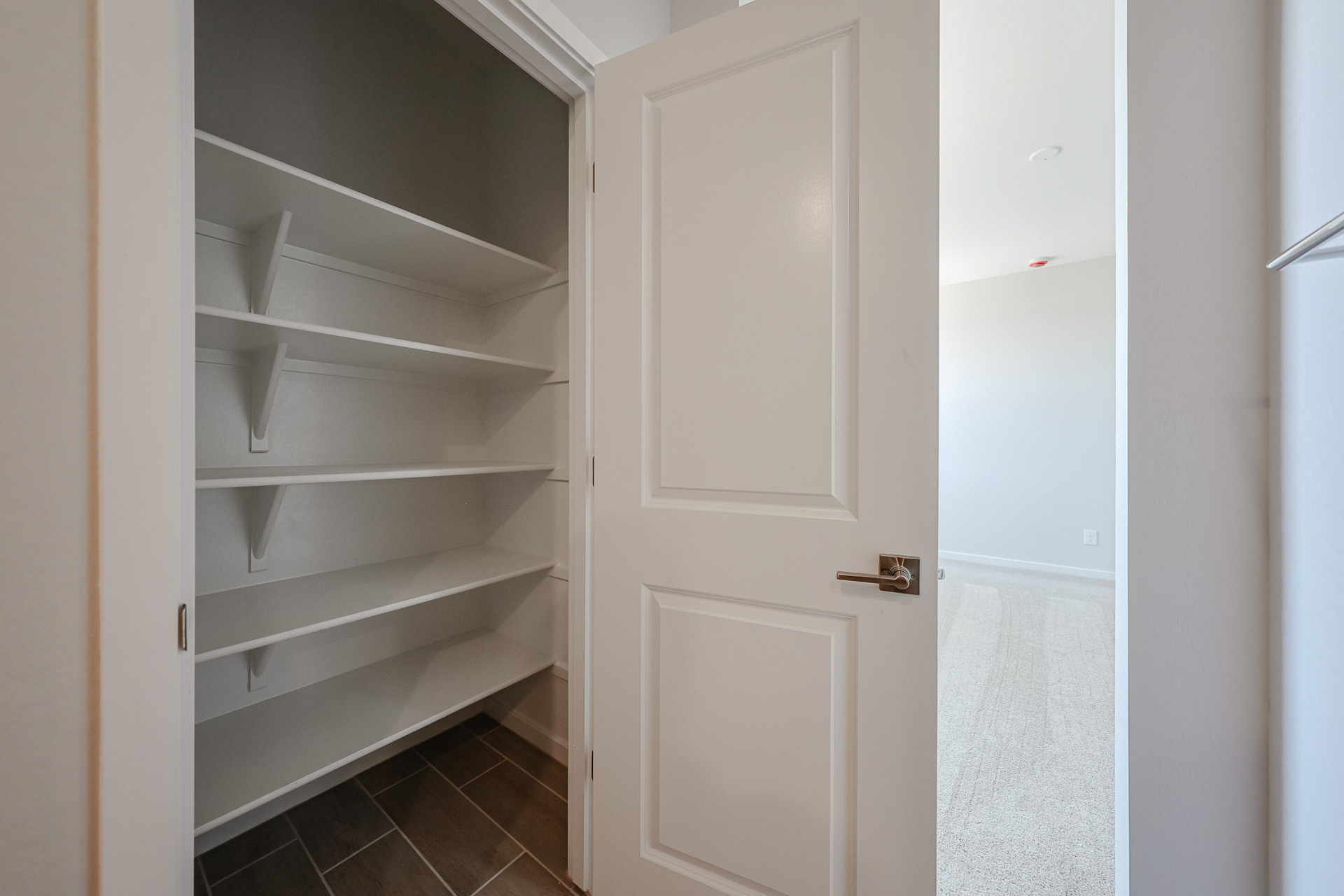 A white closet with a door.