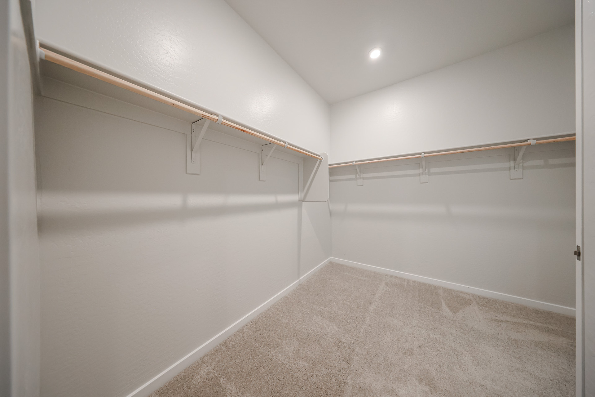 A white hallway with a metal railing.