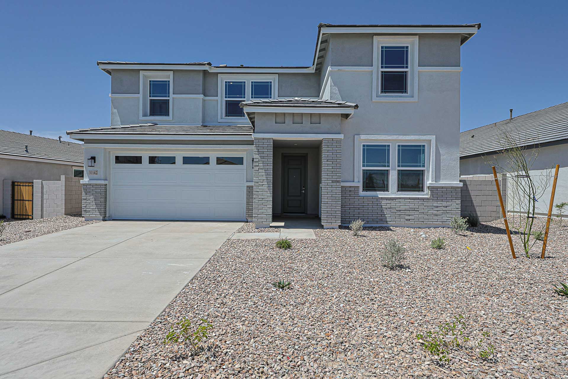 A white house with a gravel driveway.