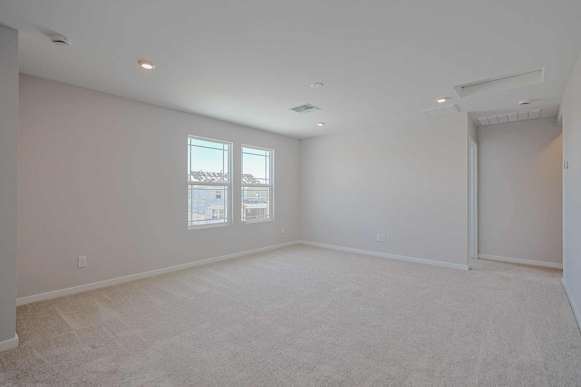 A room with a carpet and windows.