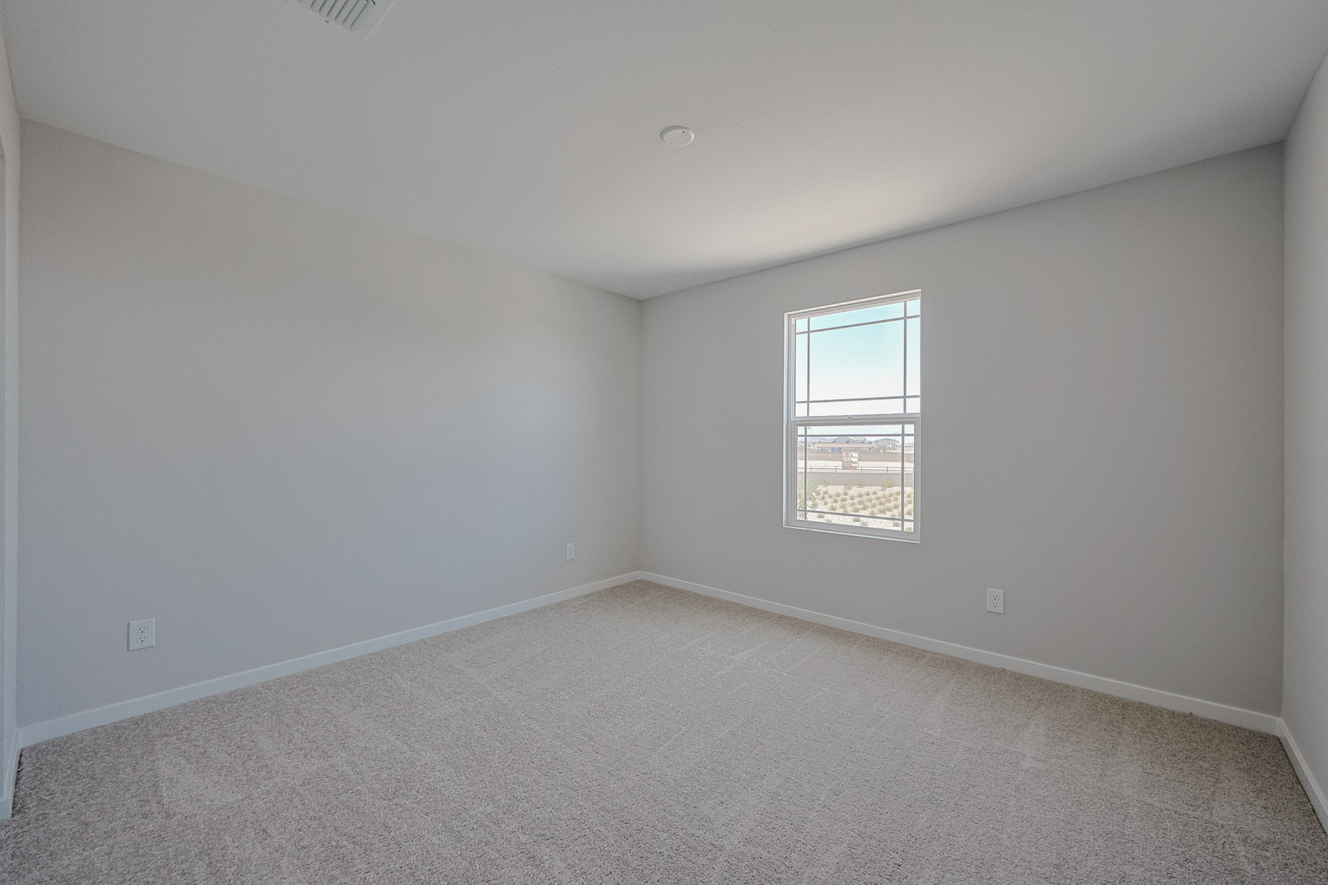A room with a window and carpet.