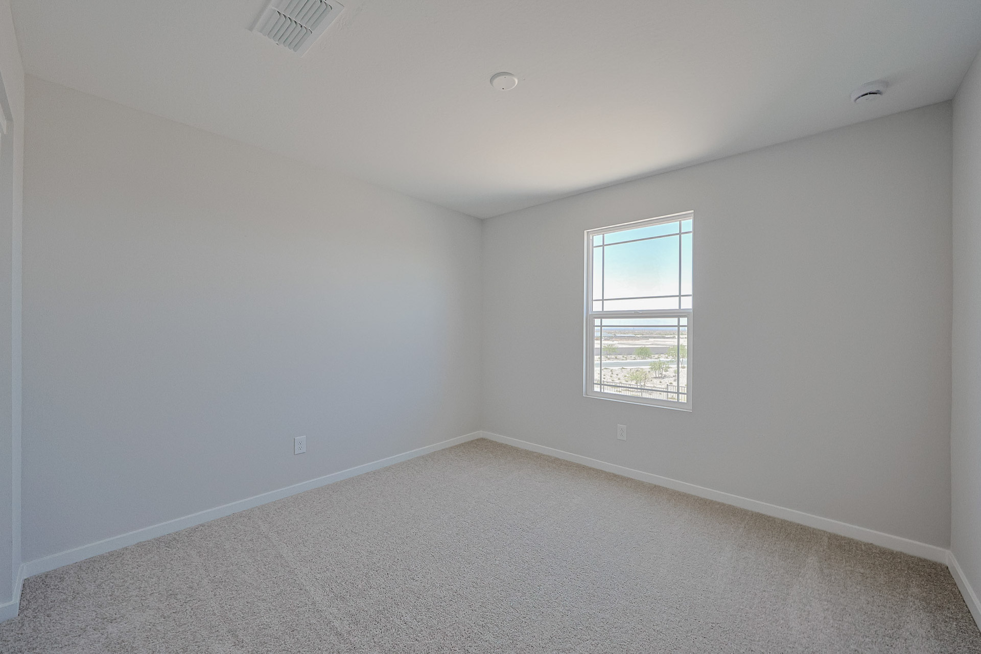 A room with a window and a carpet.